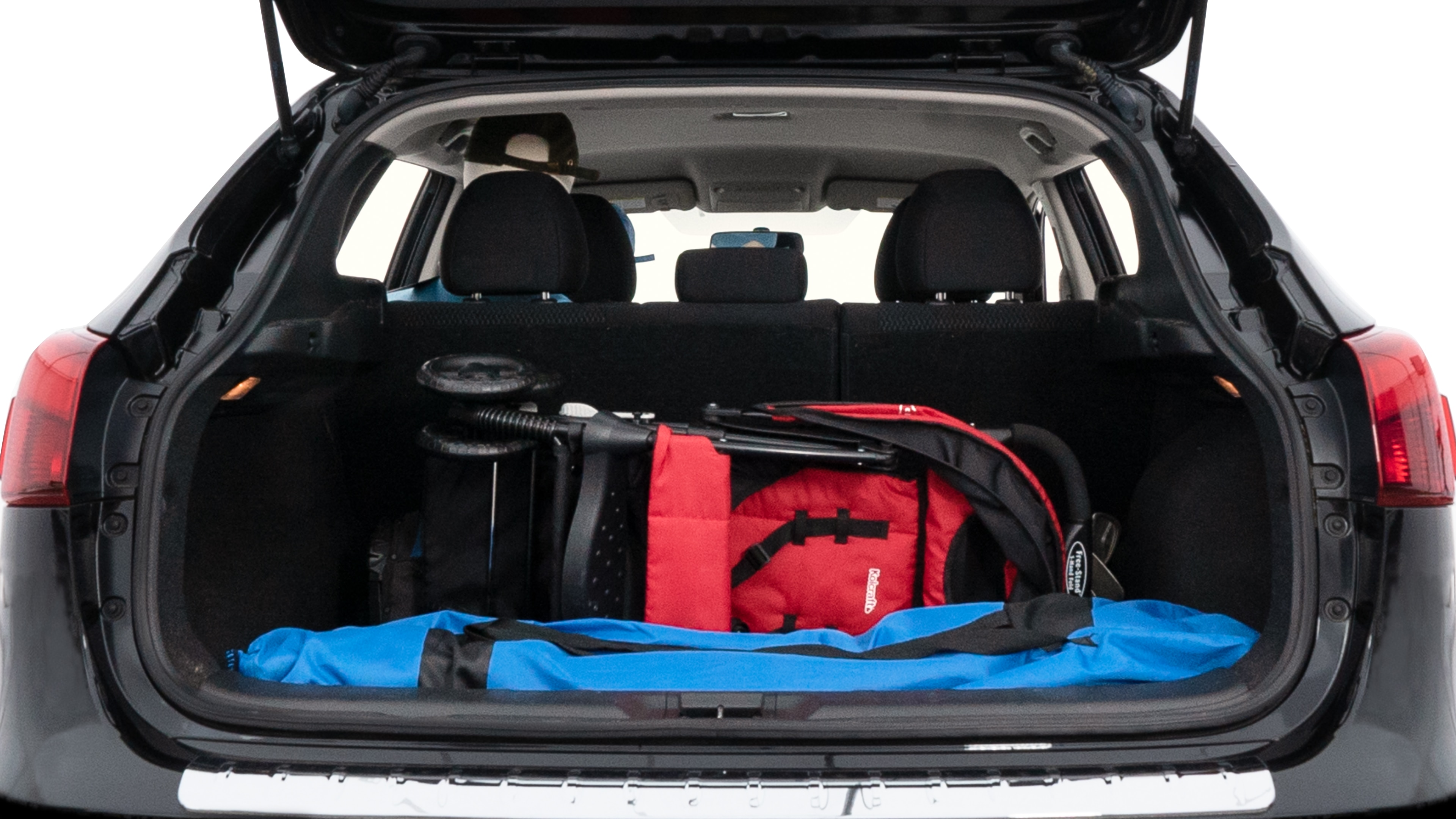 The trunk lid is open showing full view of the trunk. A baby stroller, three grocery carriers, two camping chairs in the carrying bag, and a set of golf clubs are placed inside.