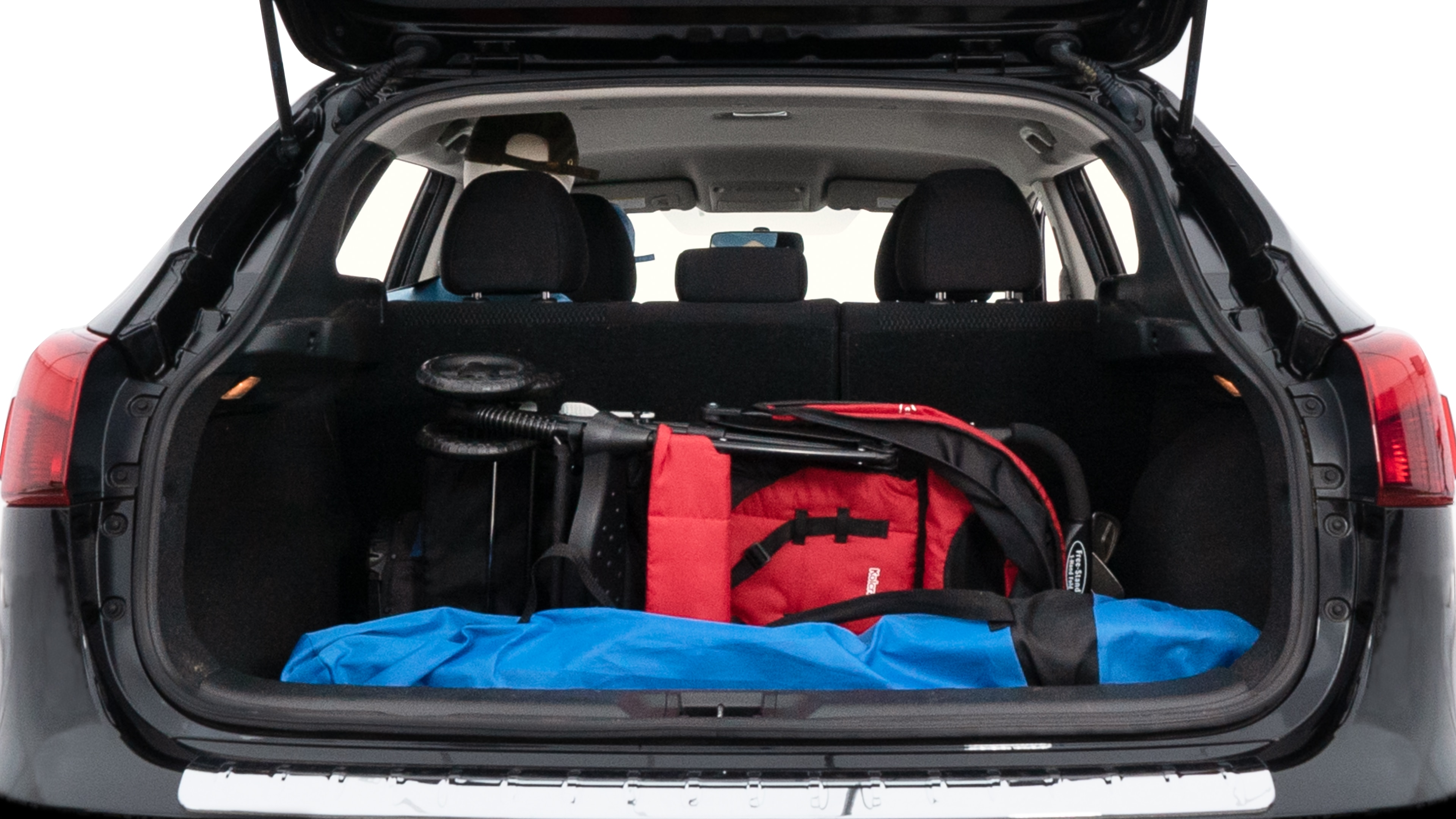 The trunk lid is open showing full view of the trunk. A baby stroller, three grocery carriers, two camping chairs in the carrying bag, and a set of golf clubs are placed inside.