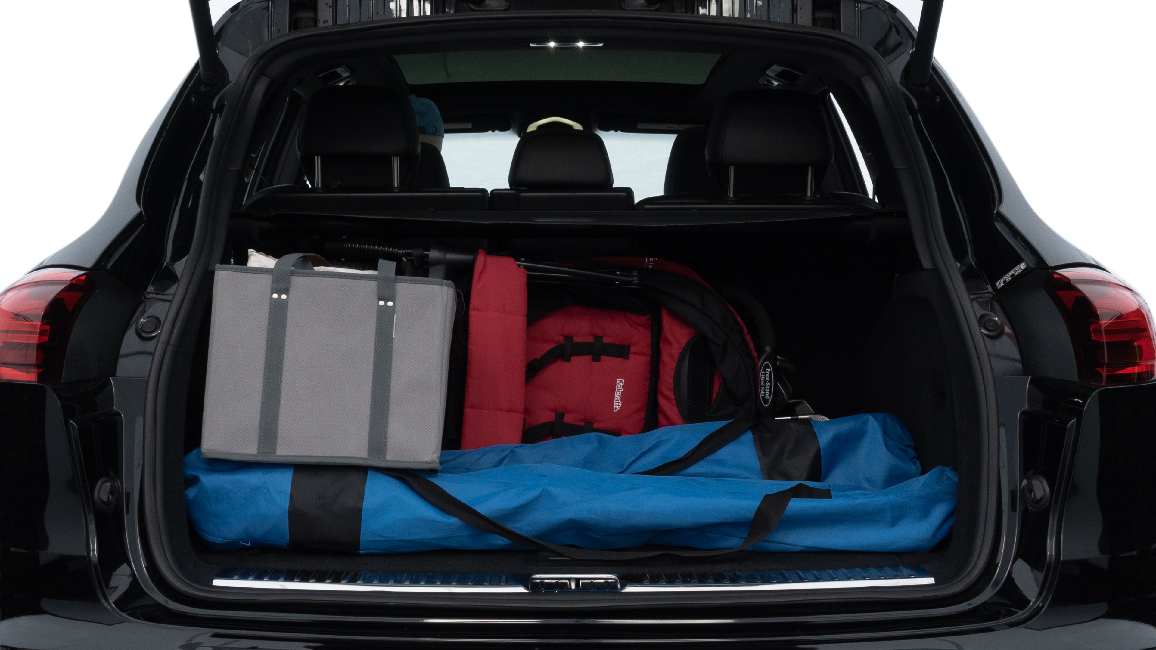 The trunk lid is open, showing full view of the trunk space. Two medium and two small suitcases are placed inside.