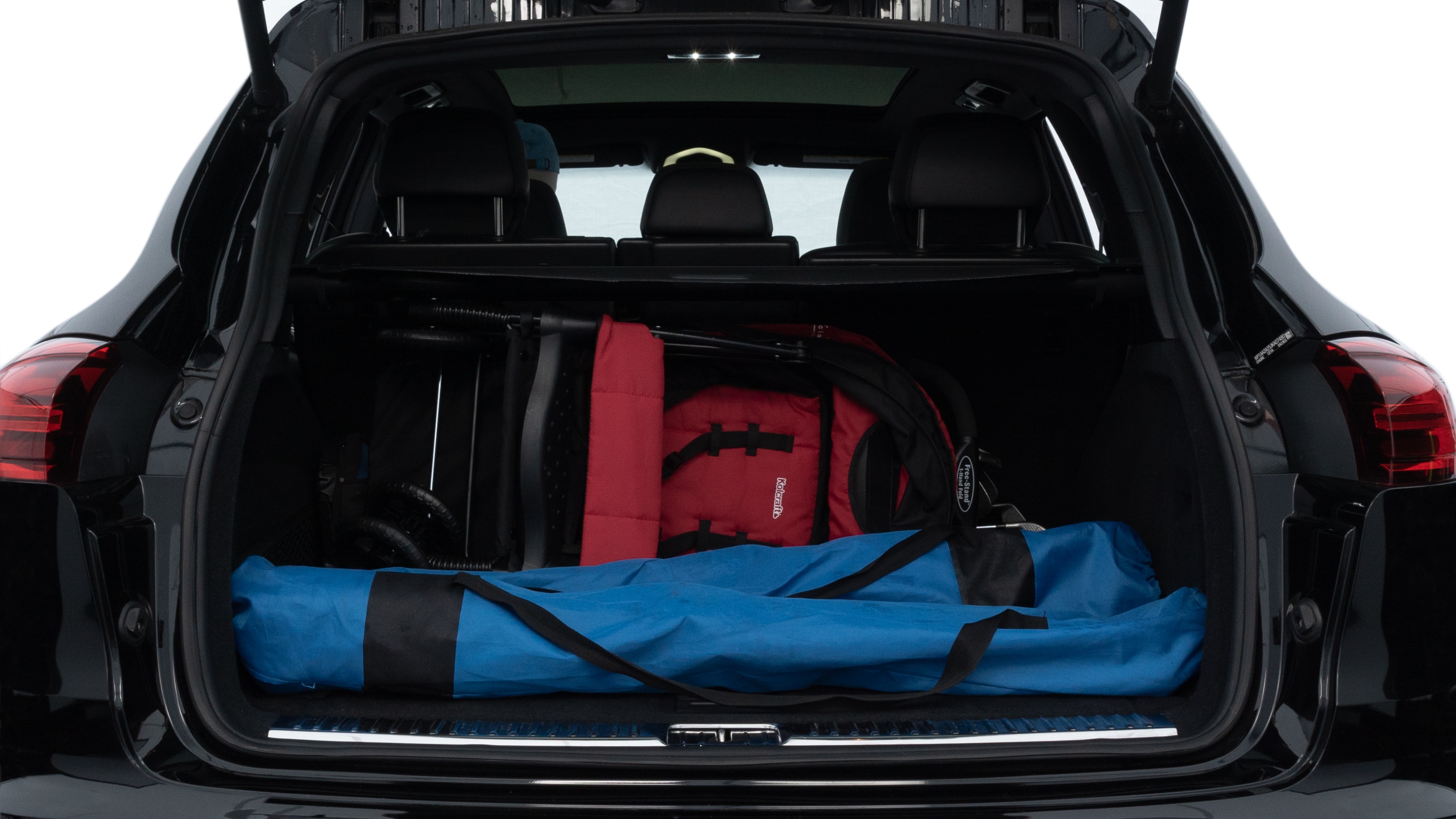 The trunk lid is open, showing full view of the trunk space. Two medium and two small suitcases are placed inside.