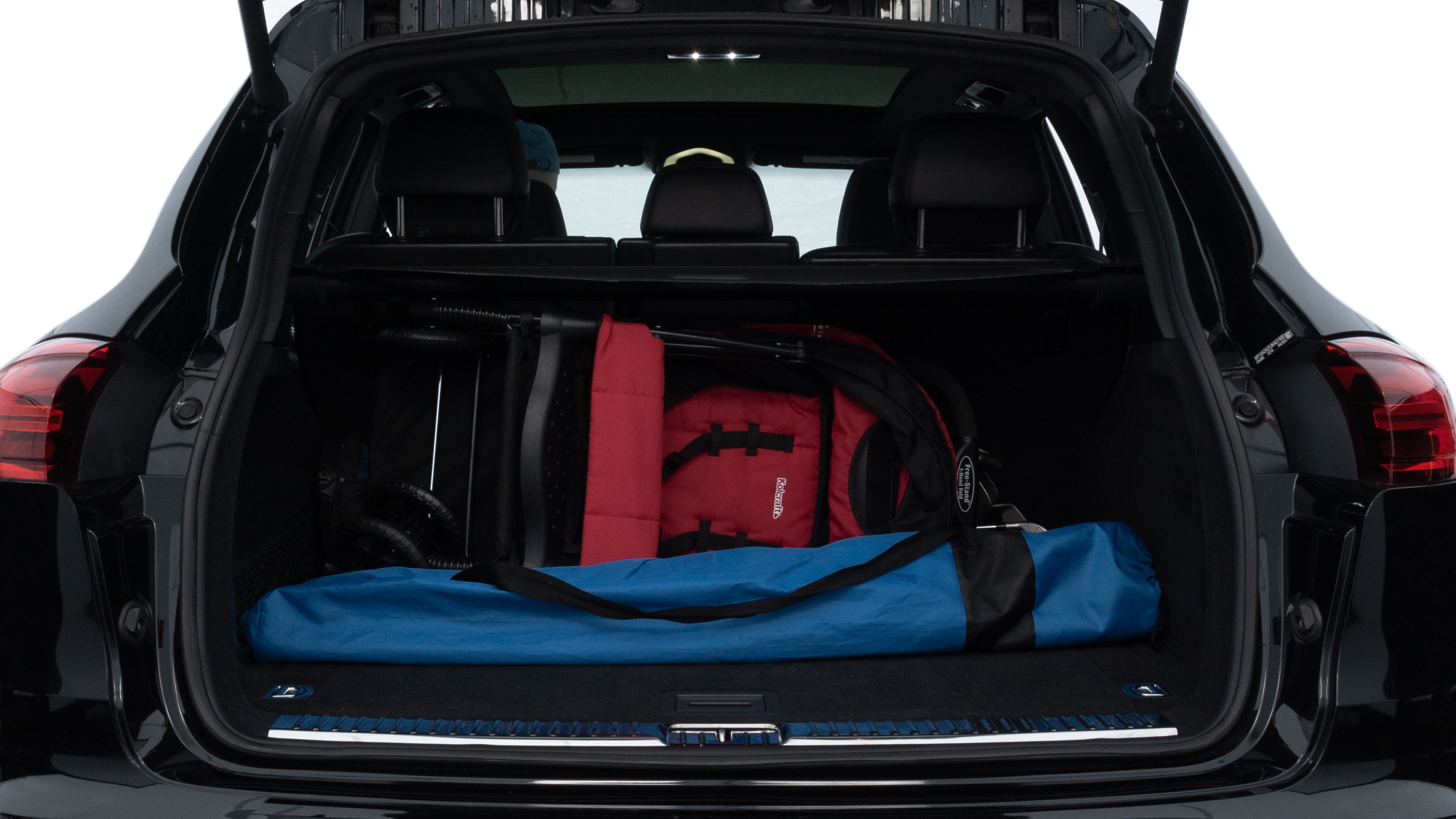 The trunk lid is open, showing full view of the trunk space. Two medium and two small suitcases are placed inside.