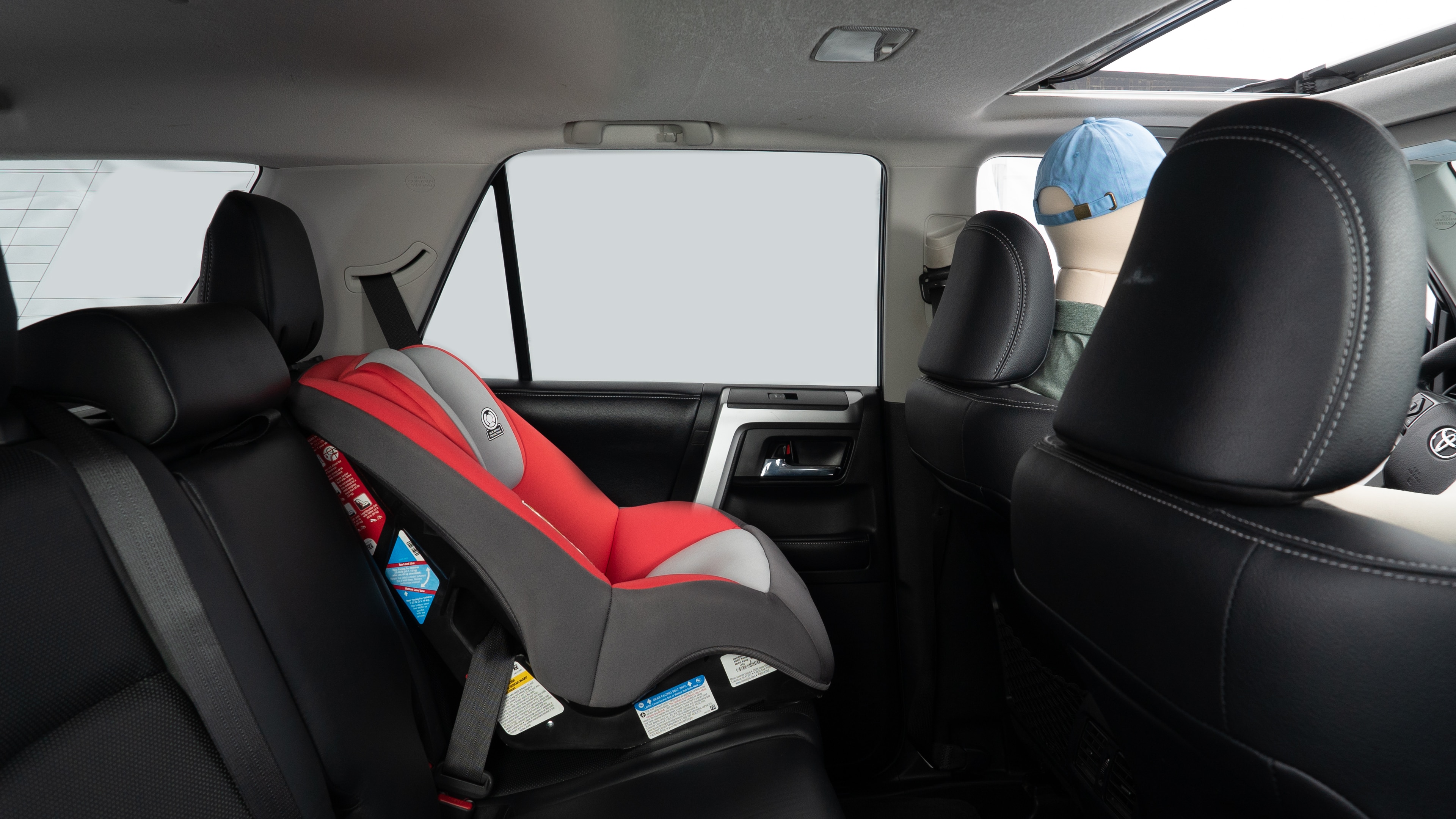 A series of second-row backseat photos is shown including one seating a baby seat and one seating a 6'1" mannequin.