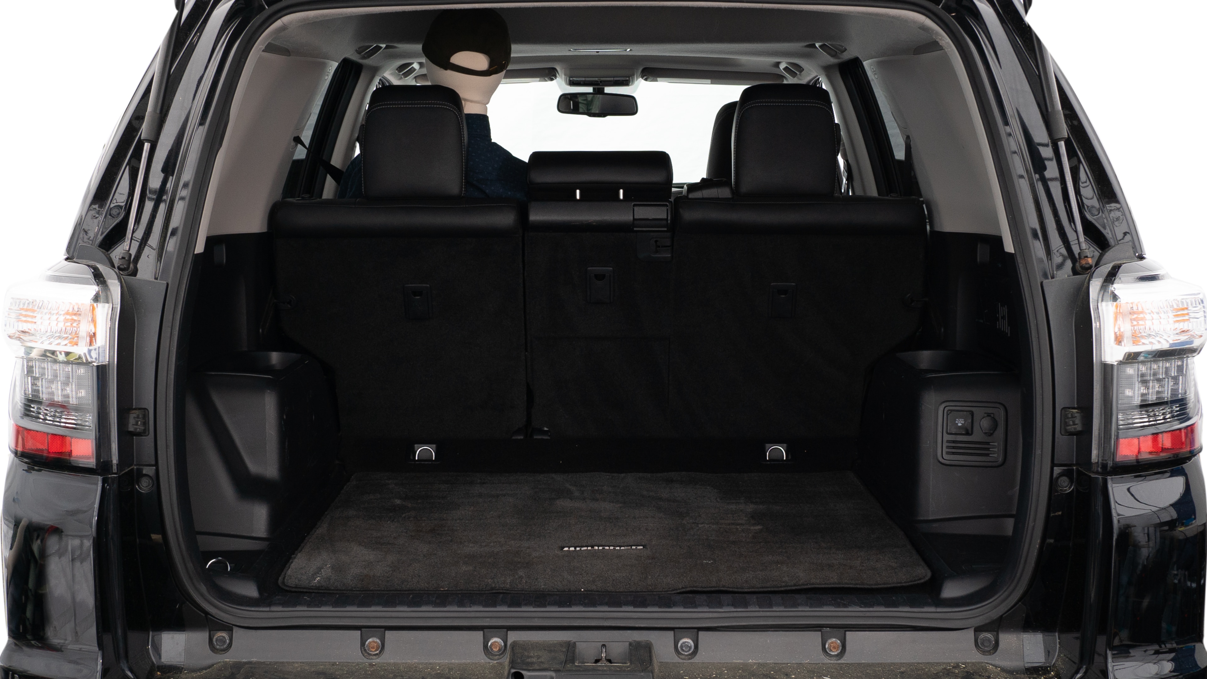 The trunk lid is open showing full view of the trunk. A baby stroller, three grocery carriers, two camping chairs in the carrying bag, and a set of golf clubs are placed inside.