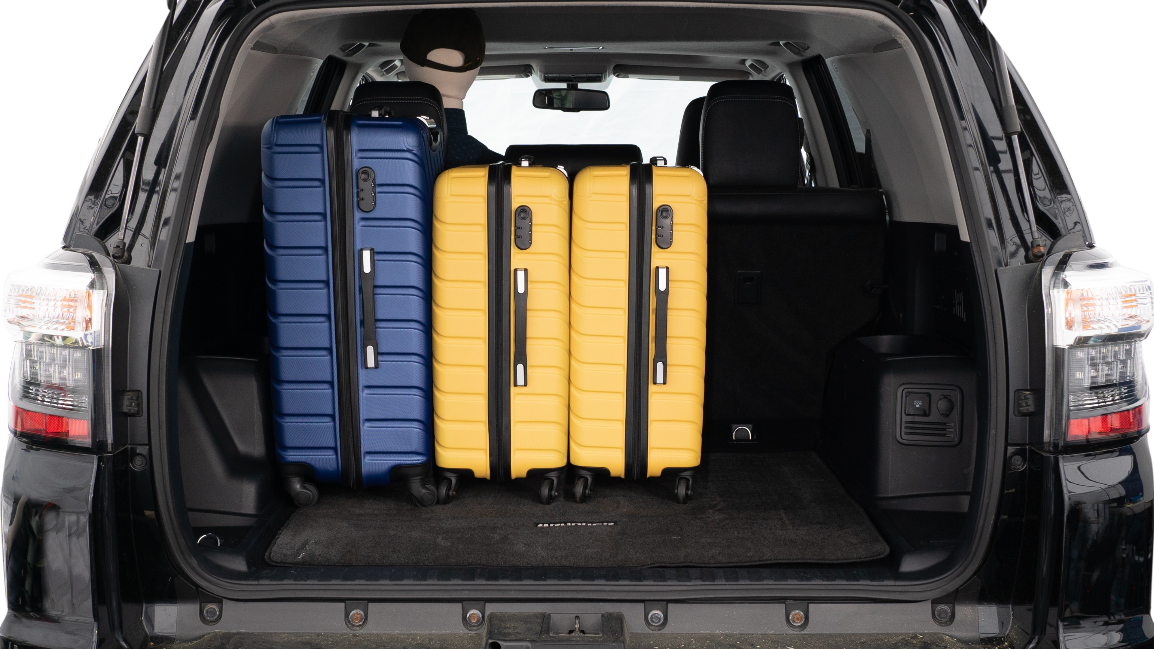 The trunk lid is open, showing a full view of the trunk space. Three large suitcases and two small suitcases are placed inside.