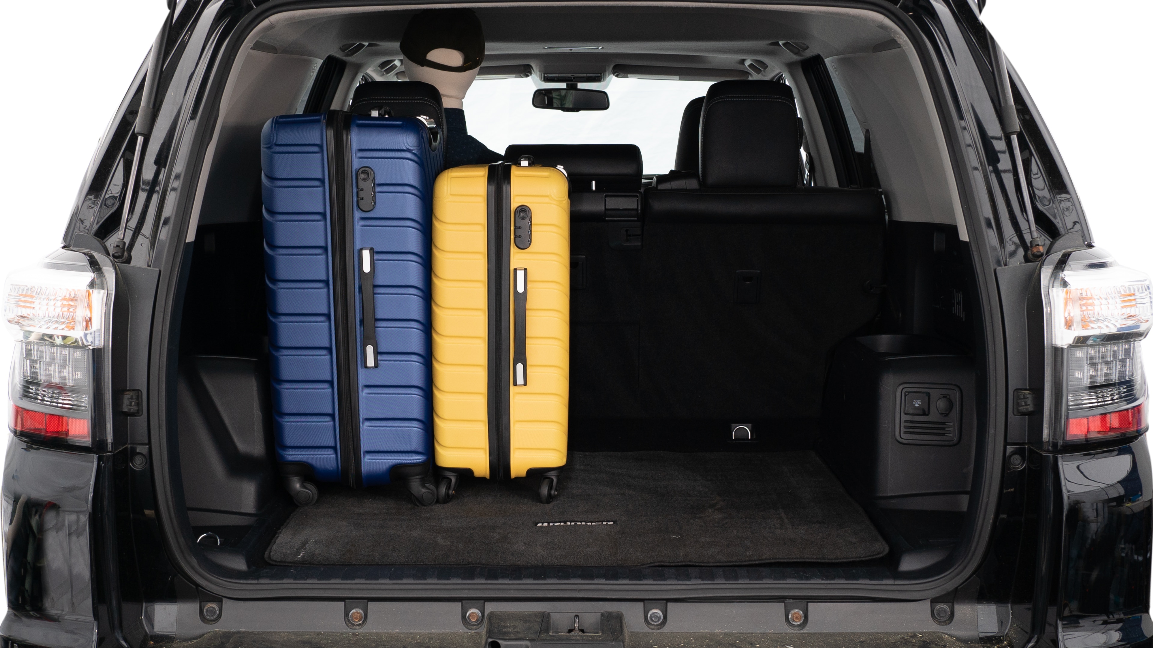 The trunk lid is open, showing a full view of the trunk space. Three large suitcases and two small suitcases are placed inside.