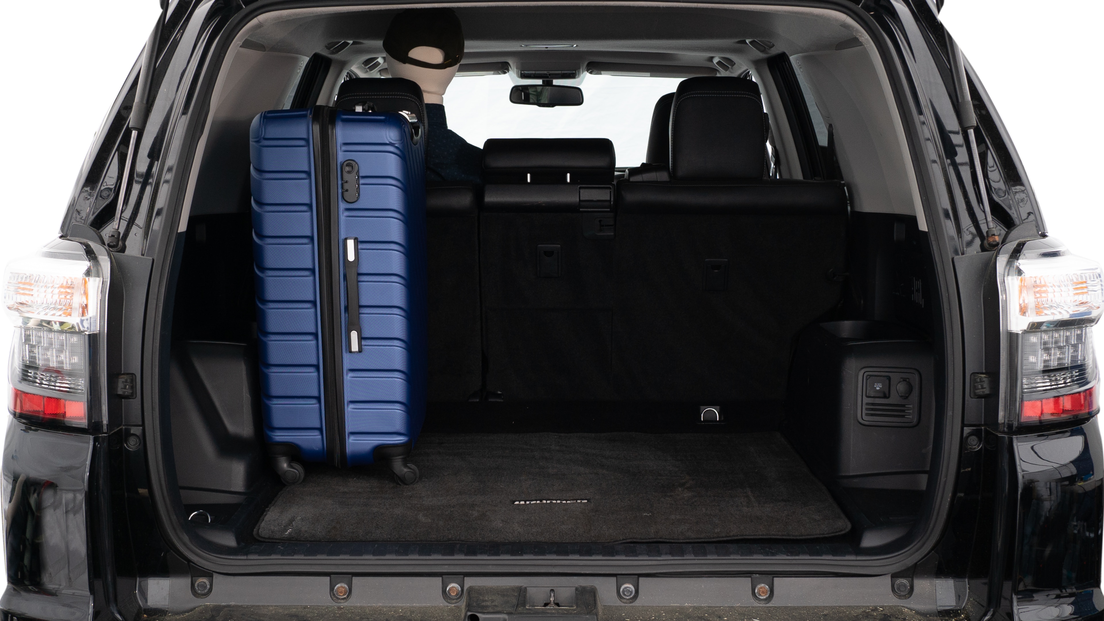 The trunk lid is open, showing a full view of the trunk space. Three large suitcases and two small suitcases are placed inside.