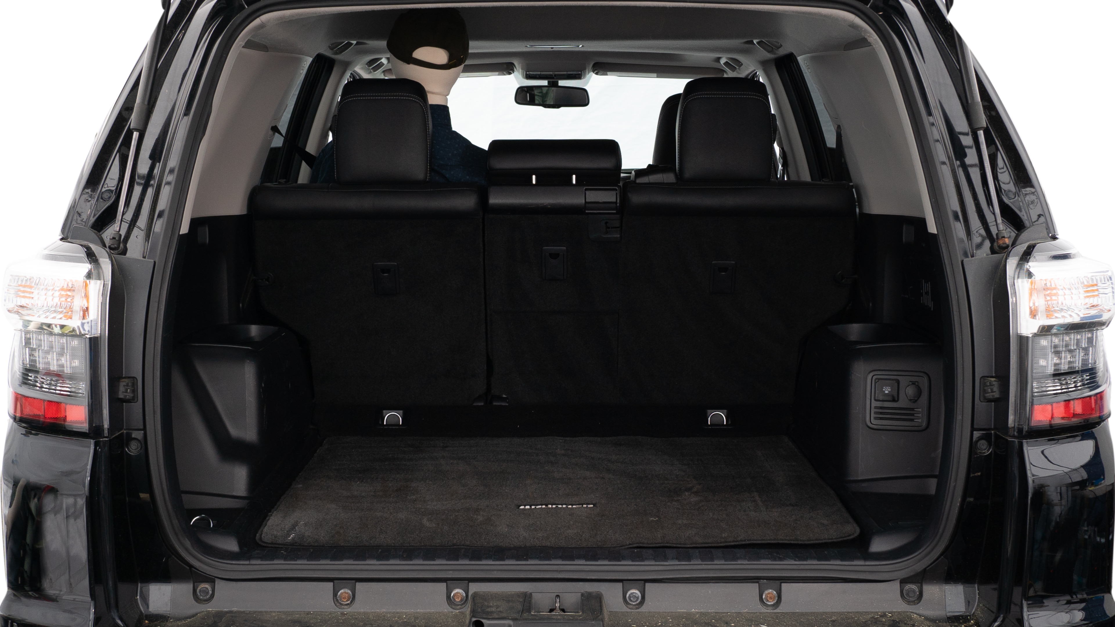 The trunk lid is open, showing a full view of the trunk space. Three large suitcases and two small suitcases are placed inside.