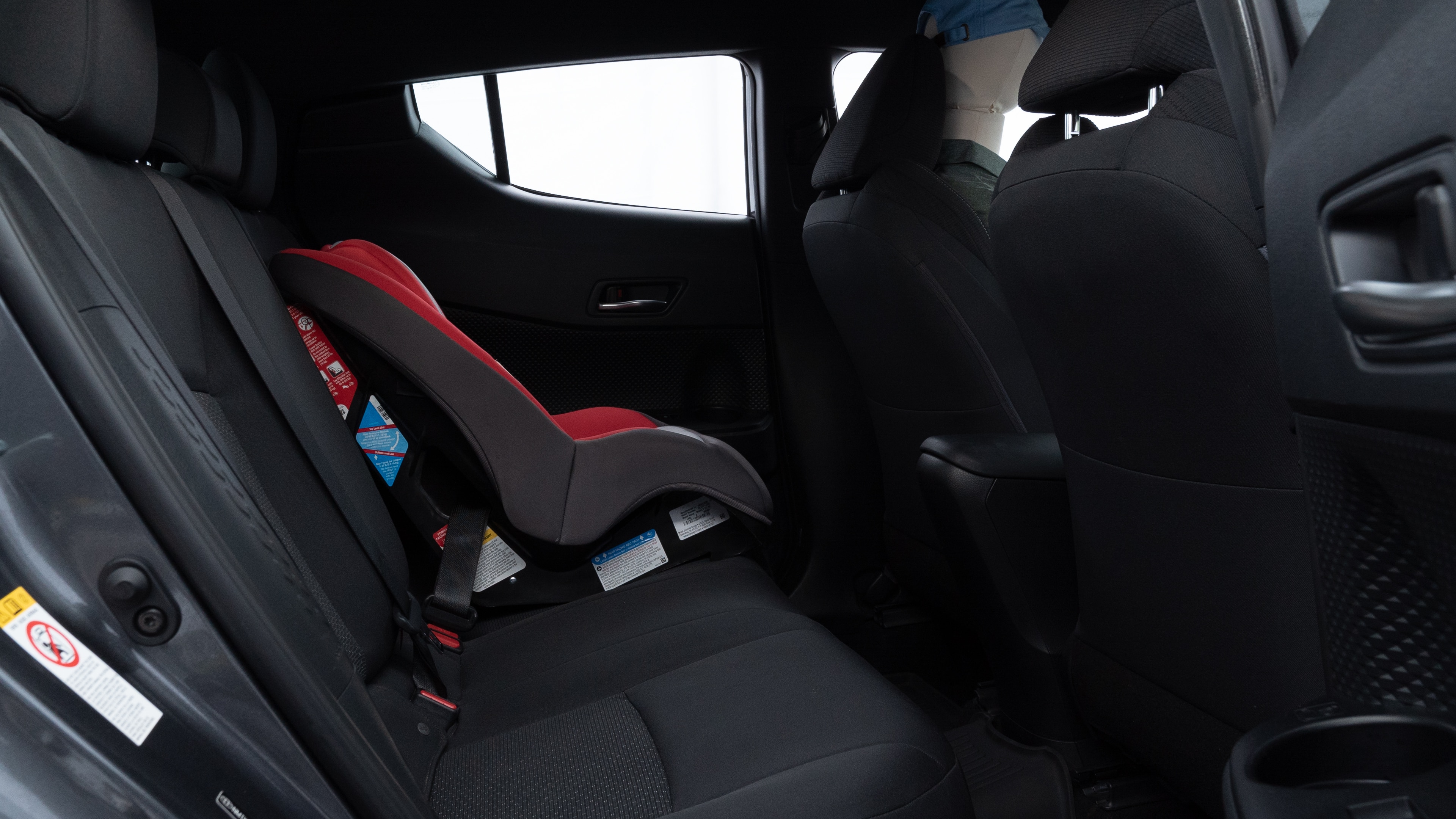 A series of second-row backseat photos is shown including one seating a baby seat and one seating a 6'1" mannequin.