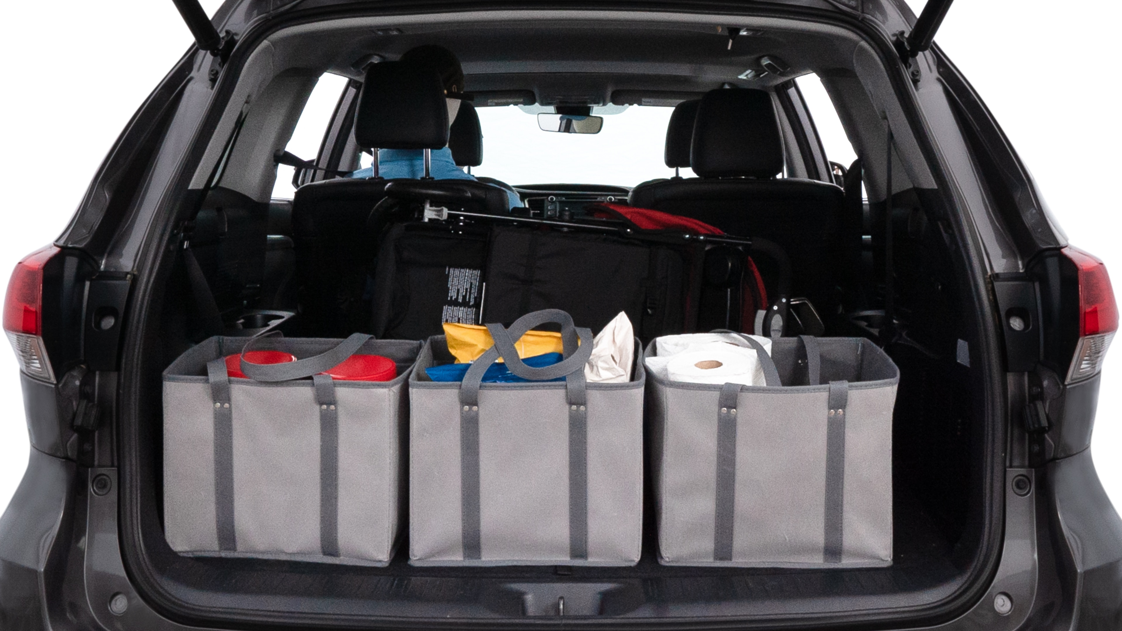 The trunk lid is open showing full view of the trunk. A baby stroller, three grocery carriers, two camping chairs in the carrying bag, and a set of golf clubs are placed inside.