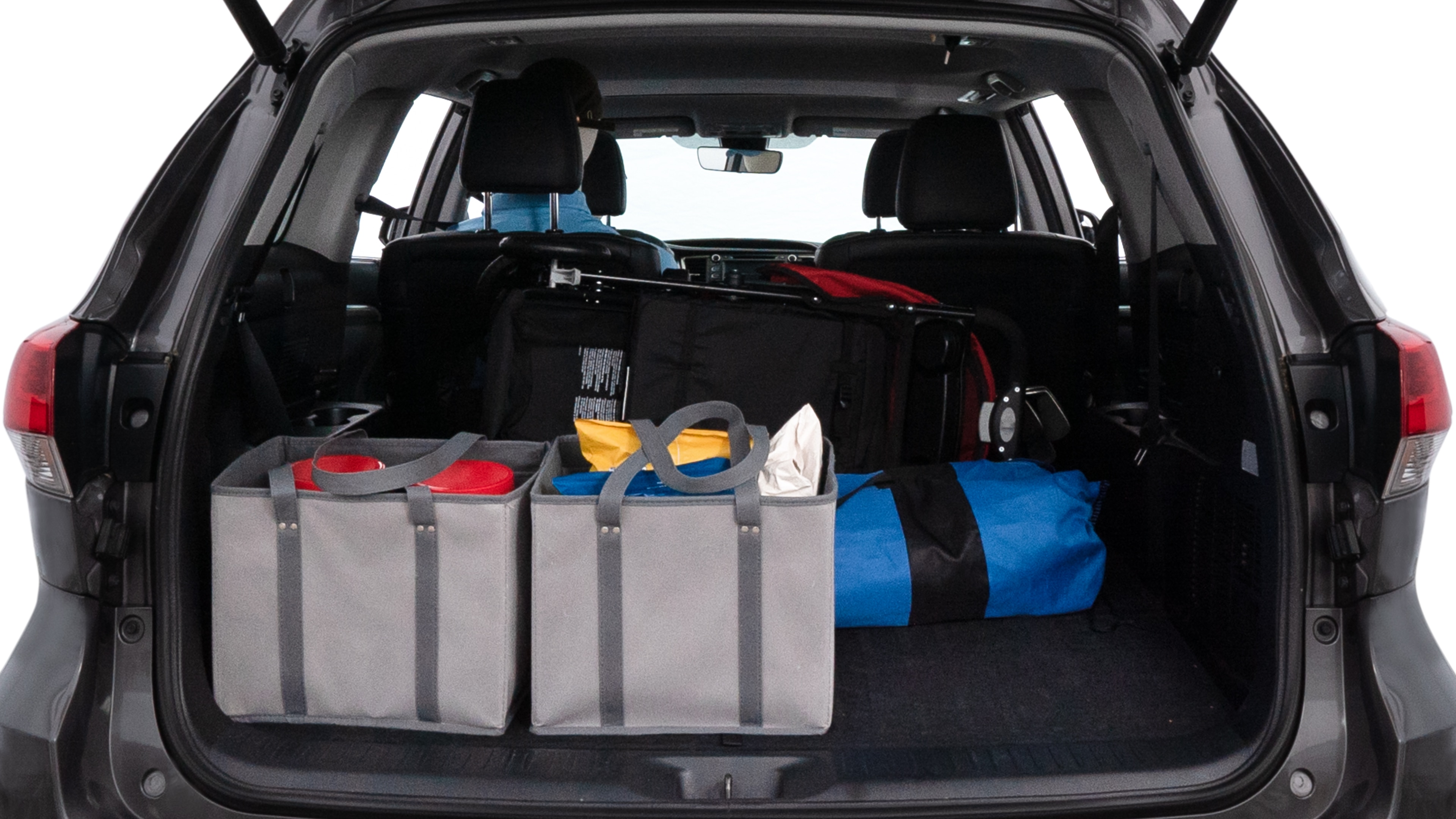 The trunk lid is open showing full view of the trunk. A baby stroller, three grocery carriers, two camping chairs in the carrying bag, and a set of golf clubs are placed inside.