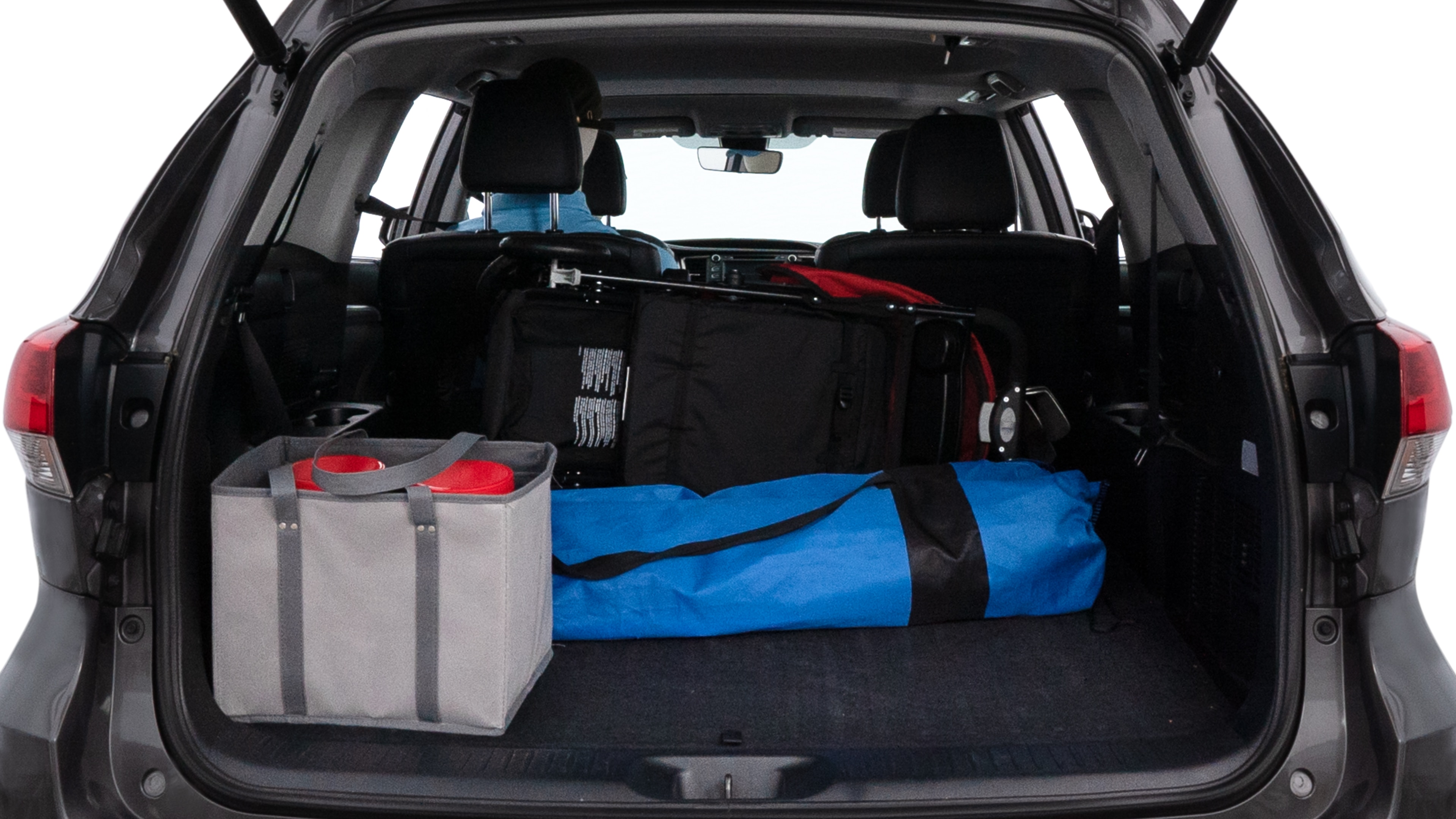 The trunk lid is open showing full view of the trunk. A baby stroller, three grocery carriers, two camping chairs in the carrying bag, and a set of golf clubs are placed inside.