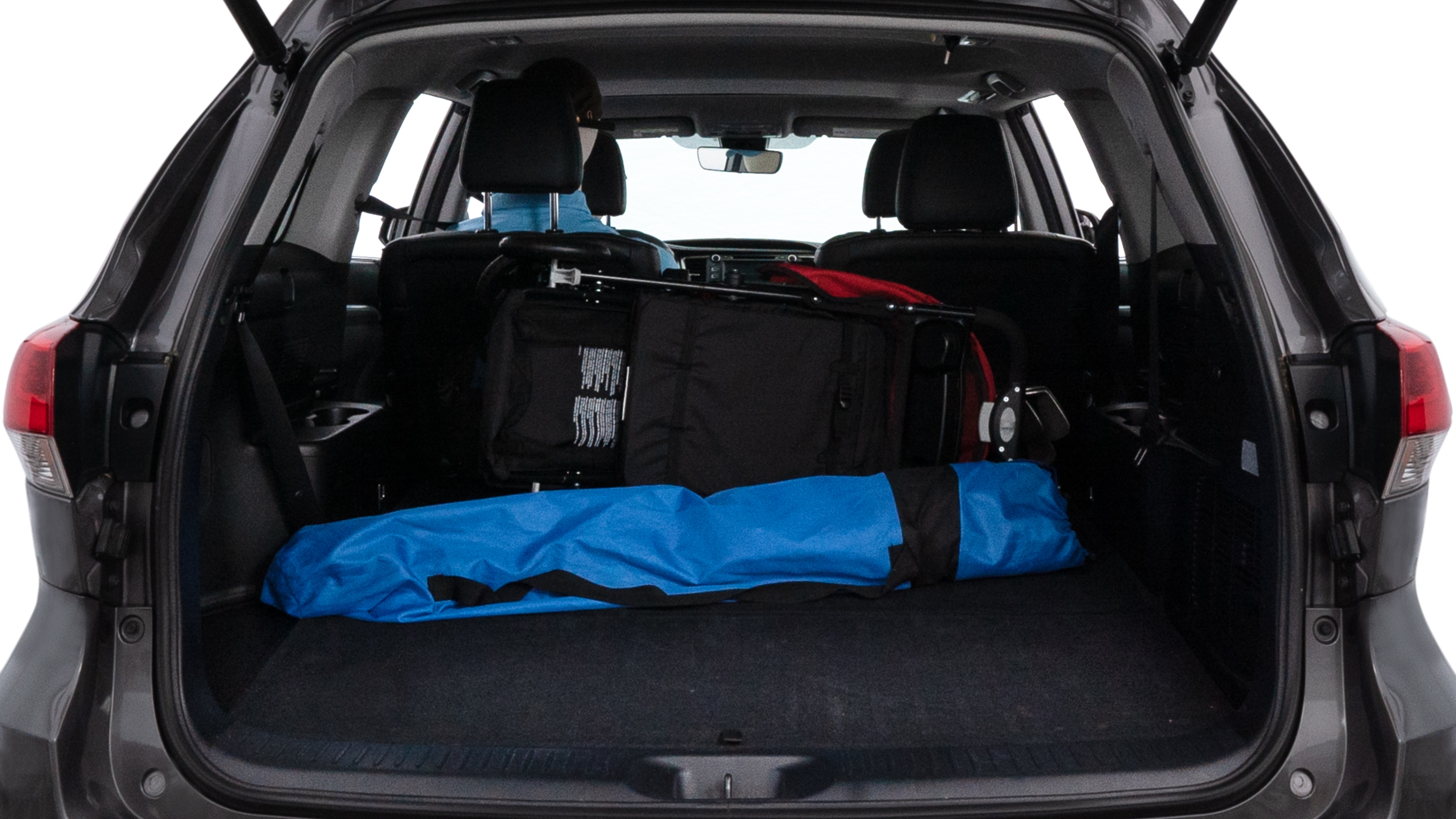 The trunk lid is open showing full view of the trunk. A baby stroller, three grocery carriers, two camping chairs in the carrying bag, and a set of golf clubs are placed inside.