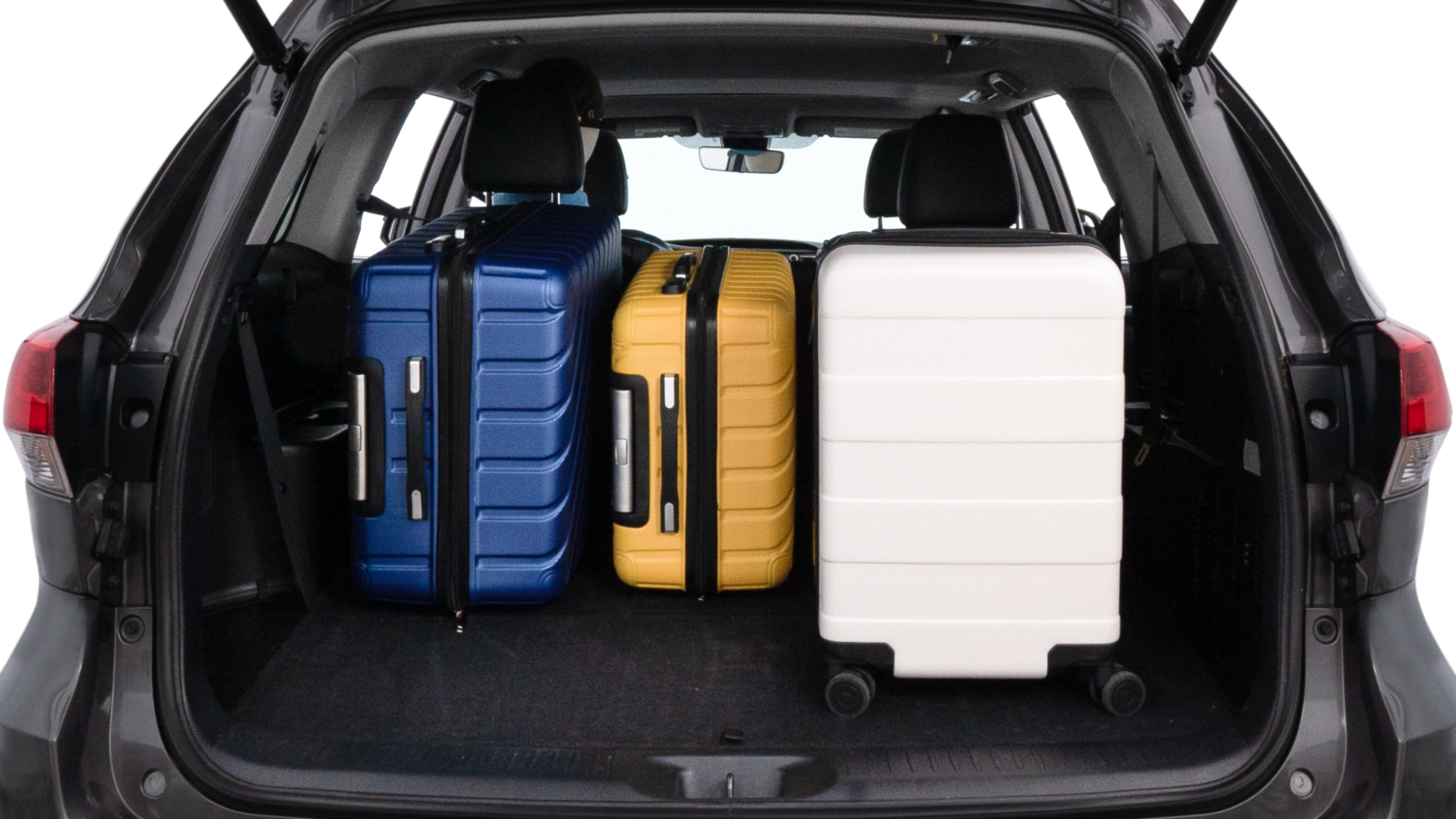 The trunk lid is open, showing full view of the trunk space. One large suitcase, two medium suitcases, and two small suitcases are placed inside.