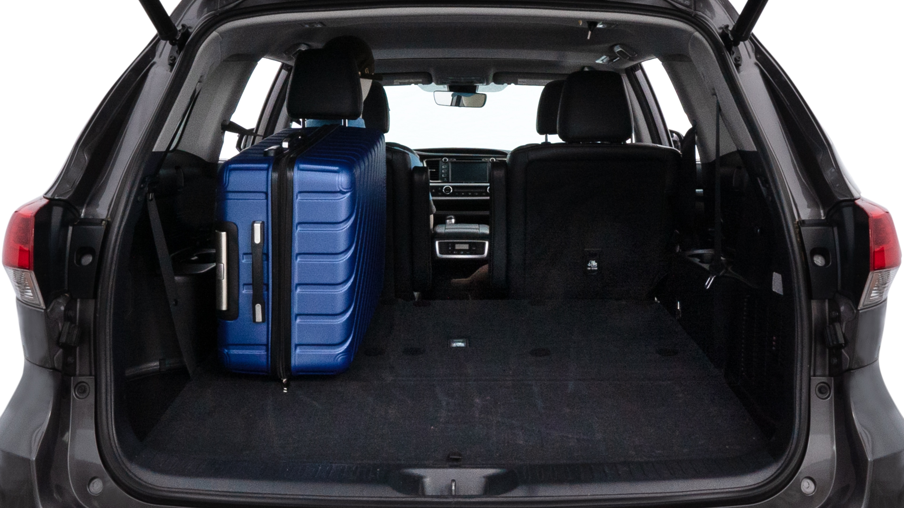 The trunk lid is open, showing full view of the trunk space. One large suitcase, two medium suitcases, and two small suitcases are placed inside.