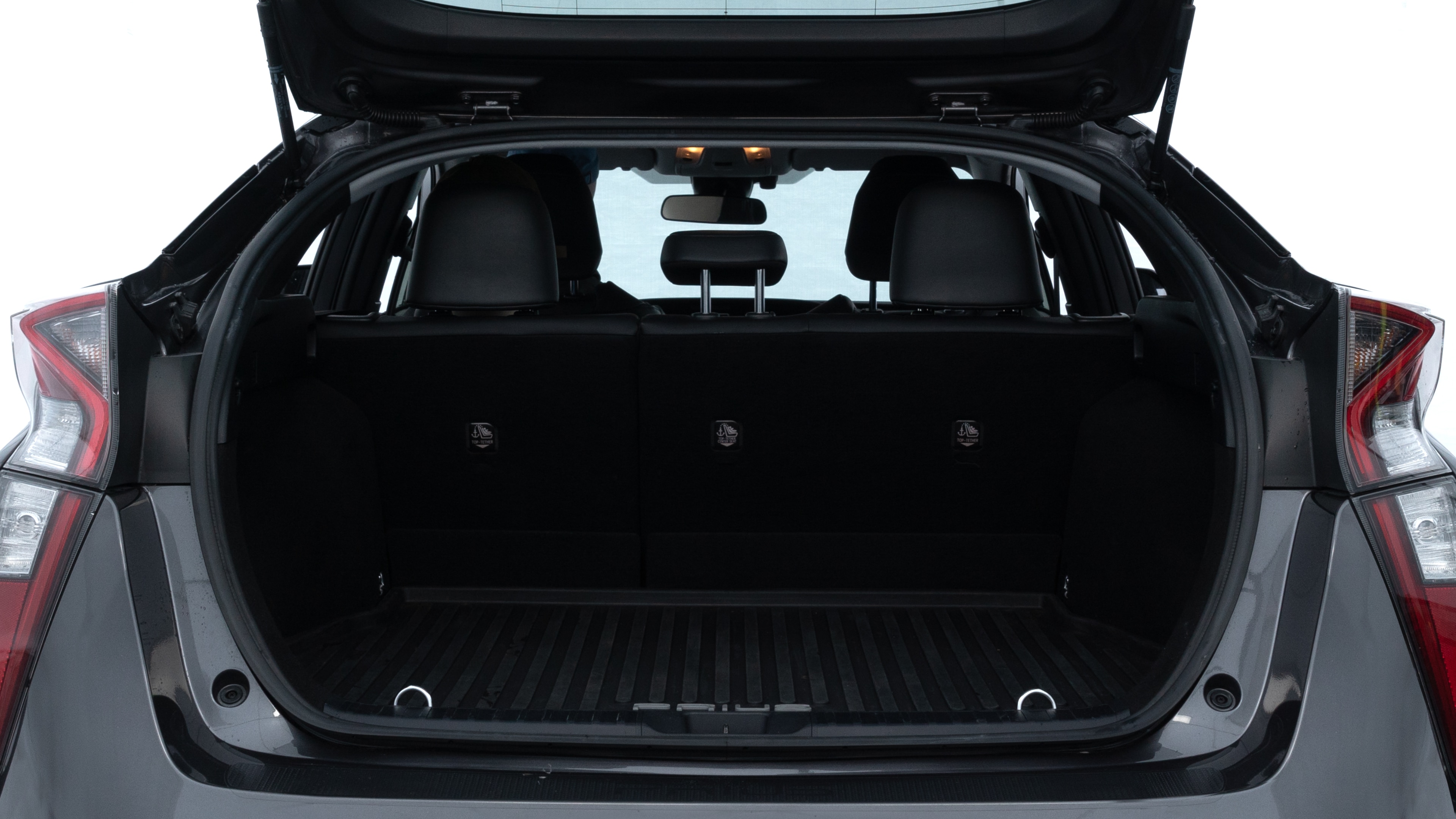 The trunk lid is open showing full view of the trunk. A baby stroller, three grocery carriers, two camping chairs in the carrying bag, and a set of golf clubs are placed inside.