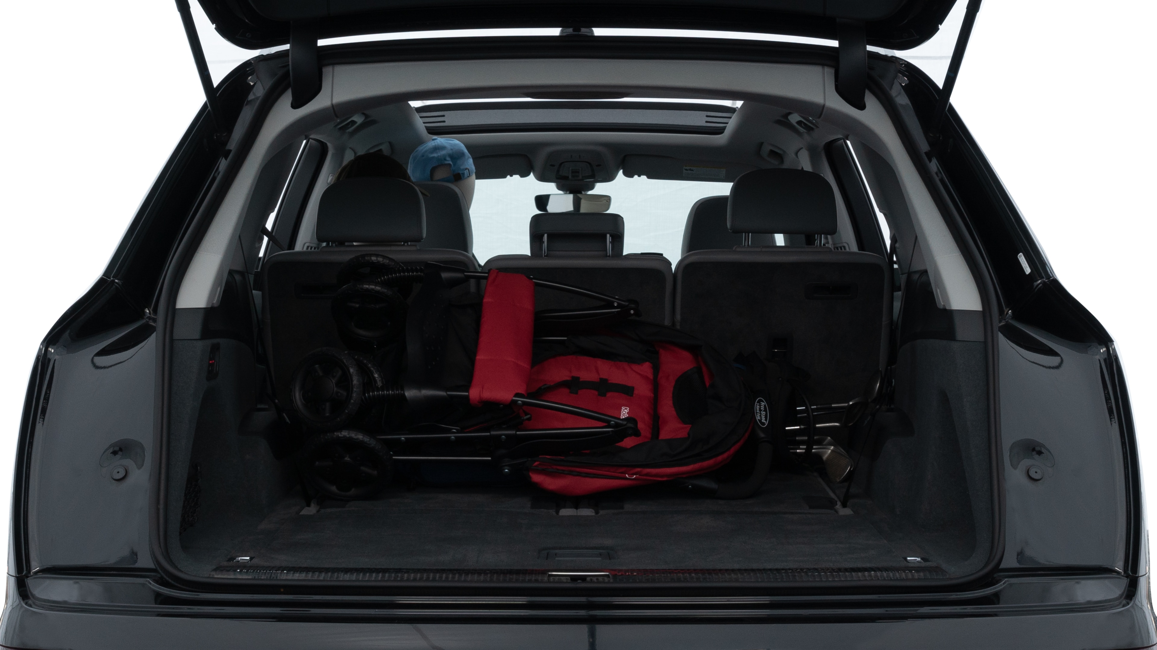 The trunk lid is open showing full view of the trunk. A baby stroller, three grocery carriers, two camping chairs in the carrying bag, and a set of golf clubs are placed inside.