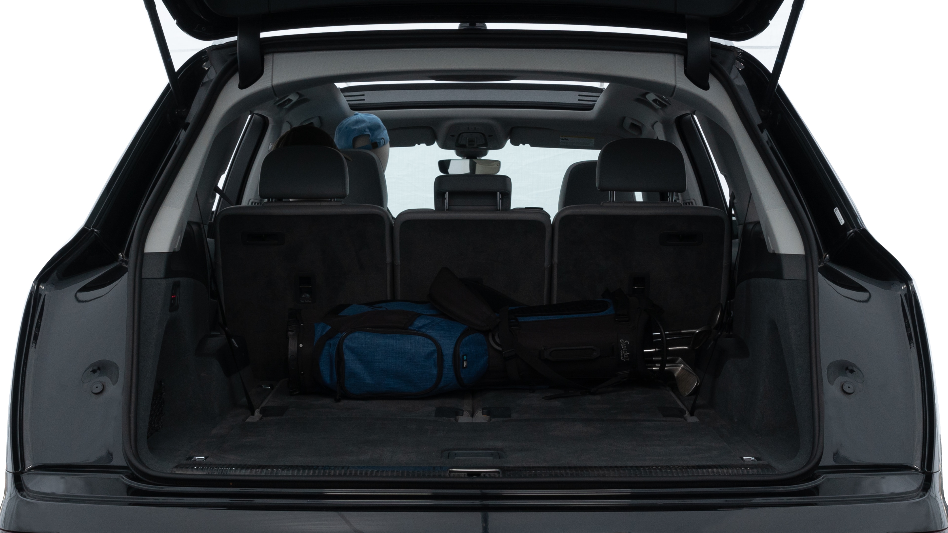 The trunk lid is open showing full view of the trunk. A baby stroller, three grocery carriers, two camping chairs in the carrying bag, and a set of golf clubs are placed inside.
