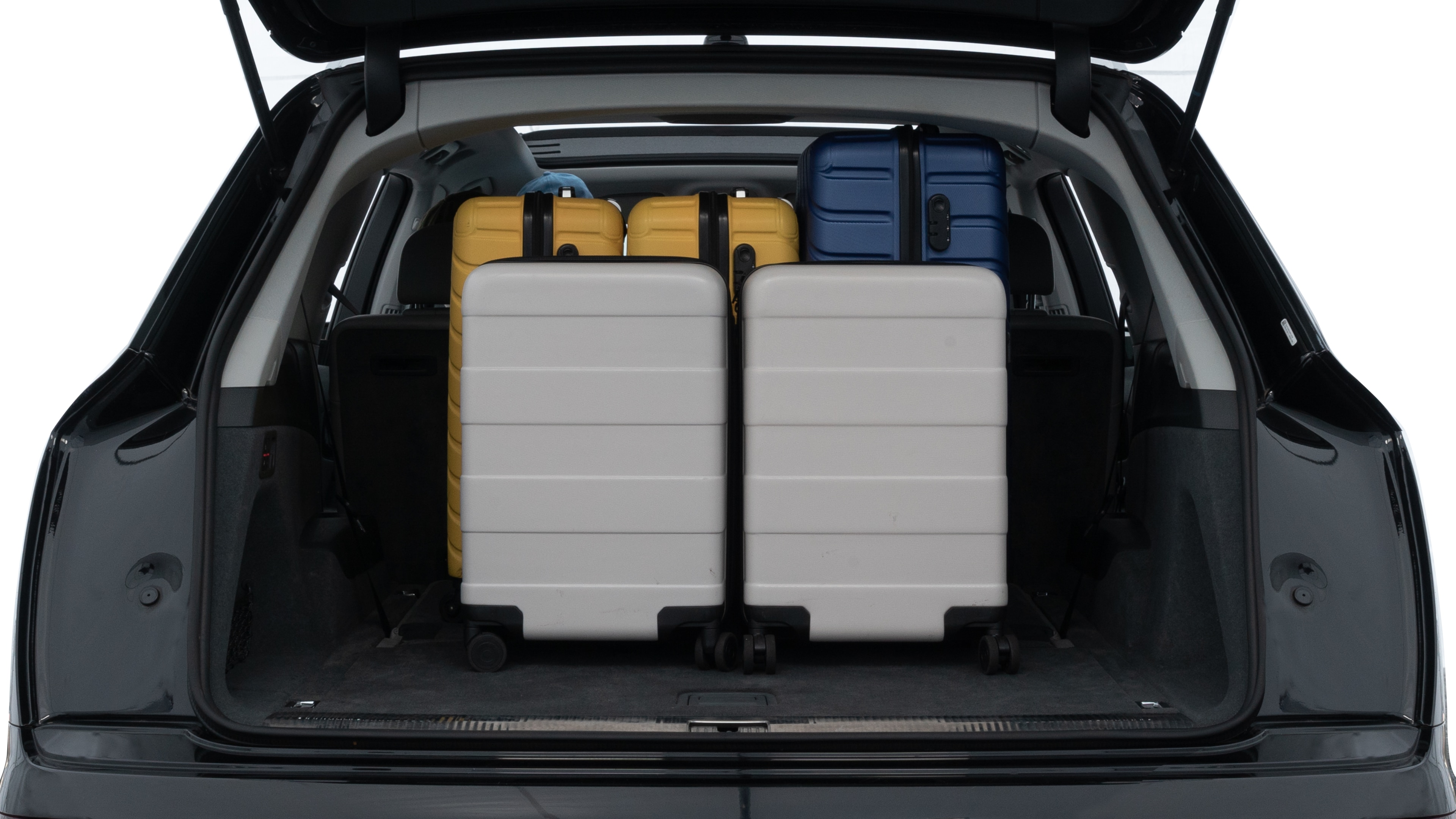 The trunk lid is open, showing full view of the trunk space. One large, two medium, and two small suitcases are placed inside.
