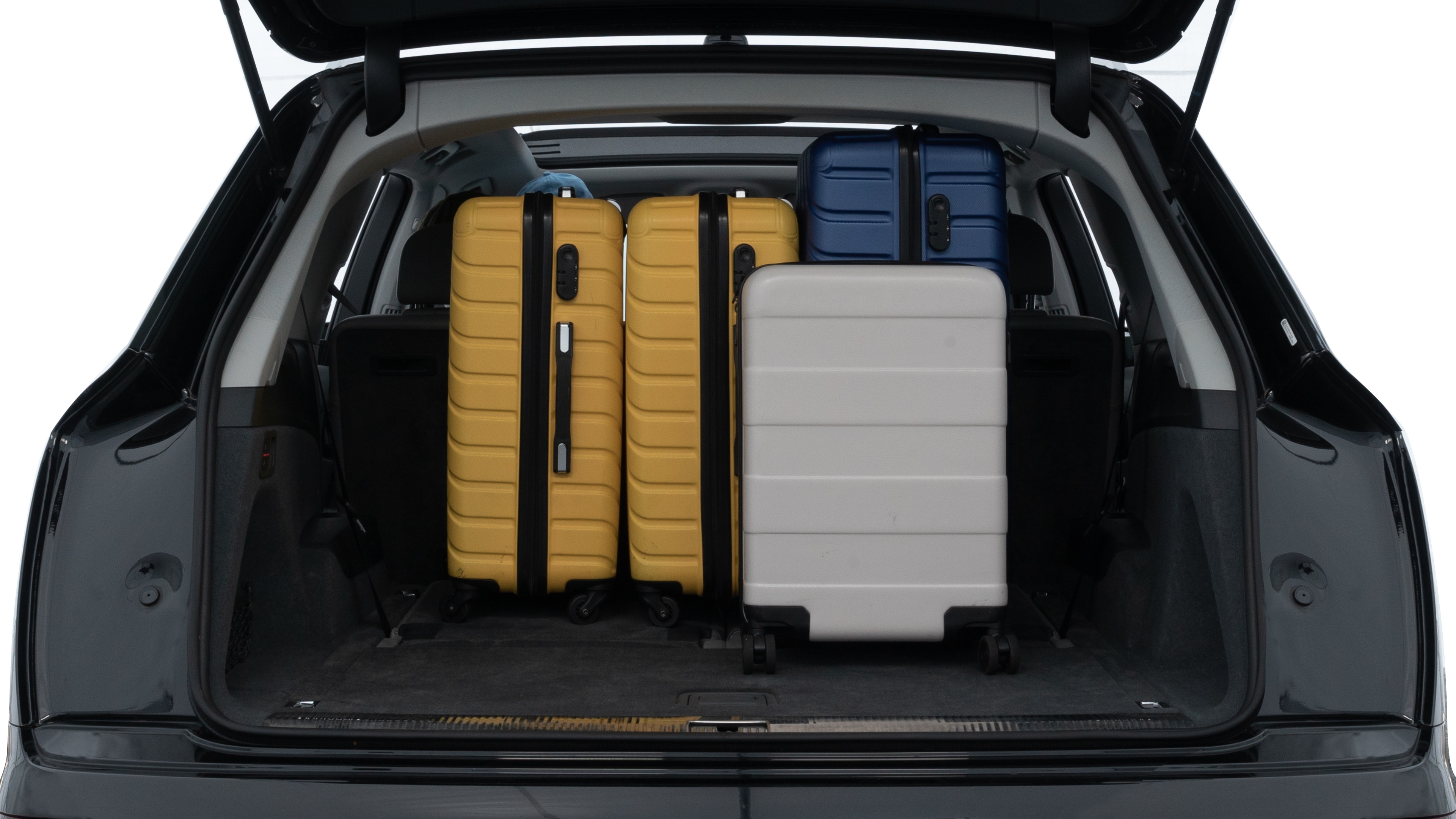 The trunk lid is open, showing full view of the trunk space. One large, two medium, and two small suitcases are placed inside.