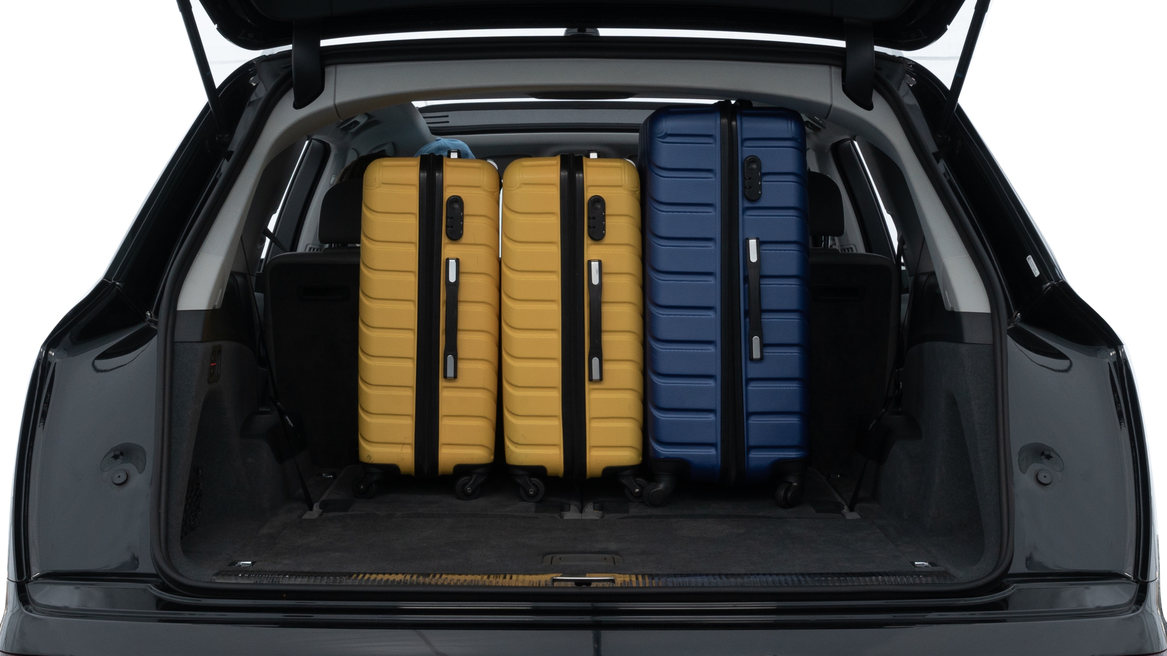 The trunk lid is open, showing full view of the trunk space. One large, two medium, and two small suitcases are placed inside.