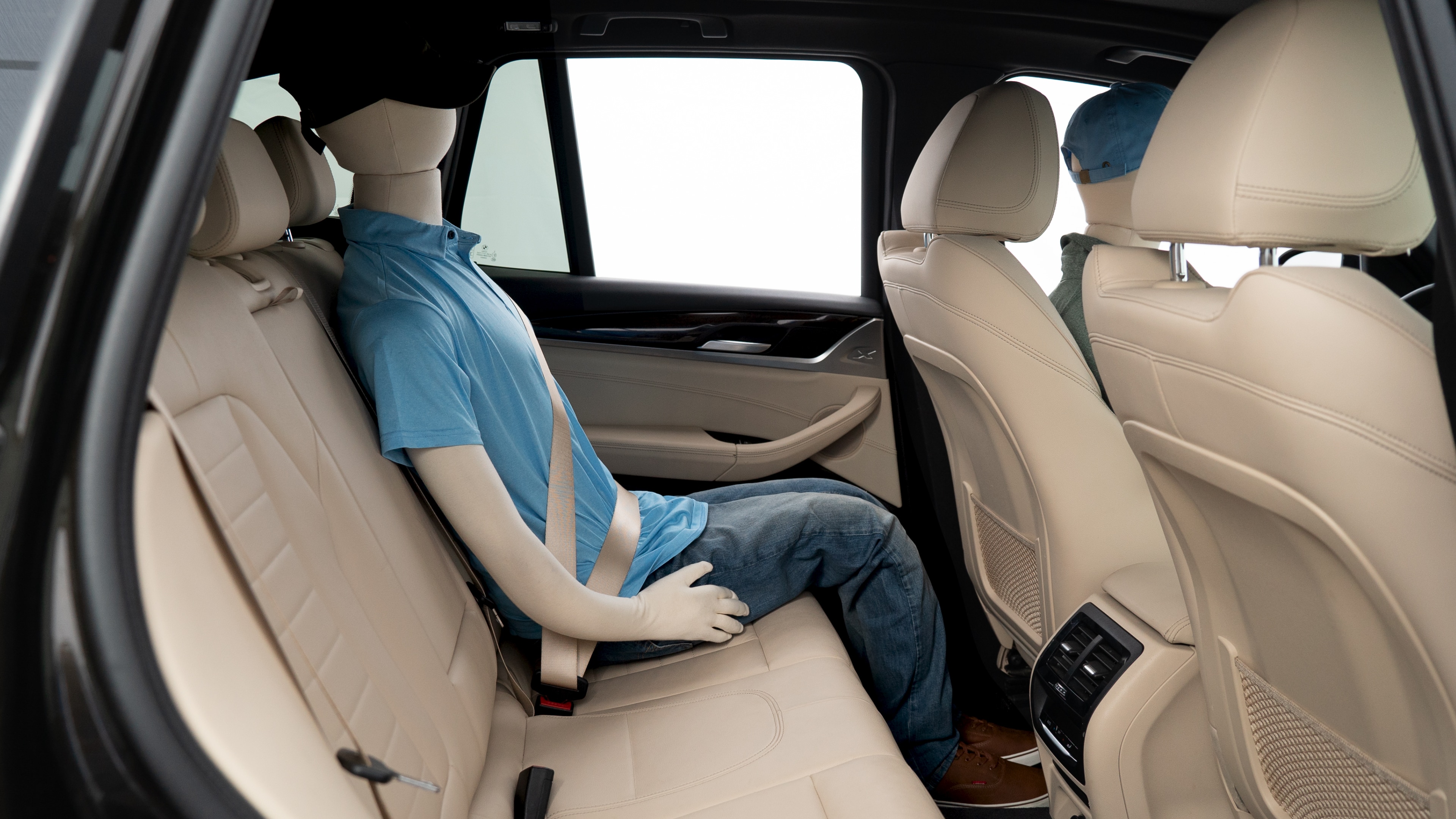 A series of second-row backseat photos is shown including one seating a baby seat, a dog and one seating a 6'1" mannequin.