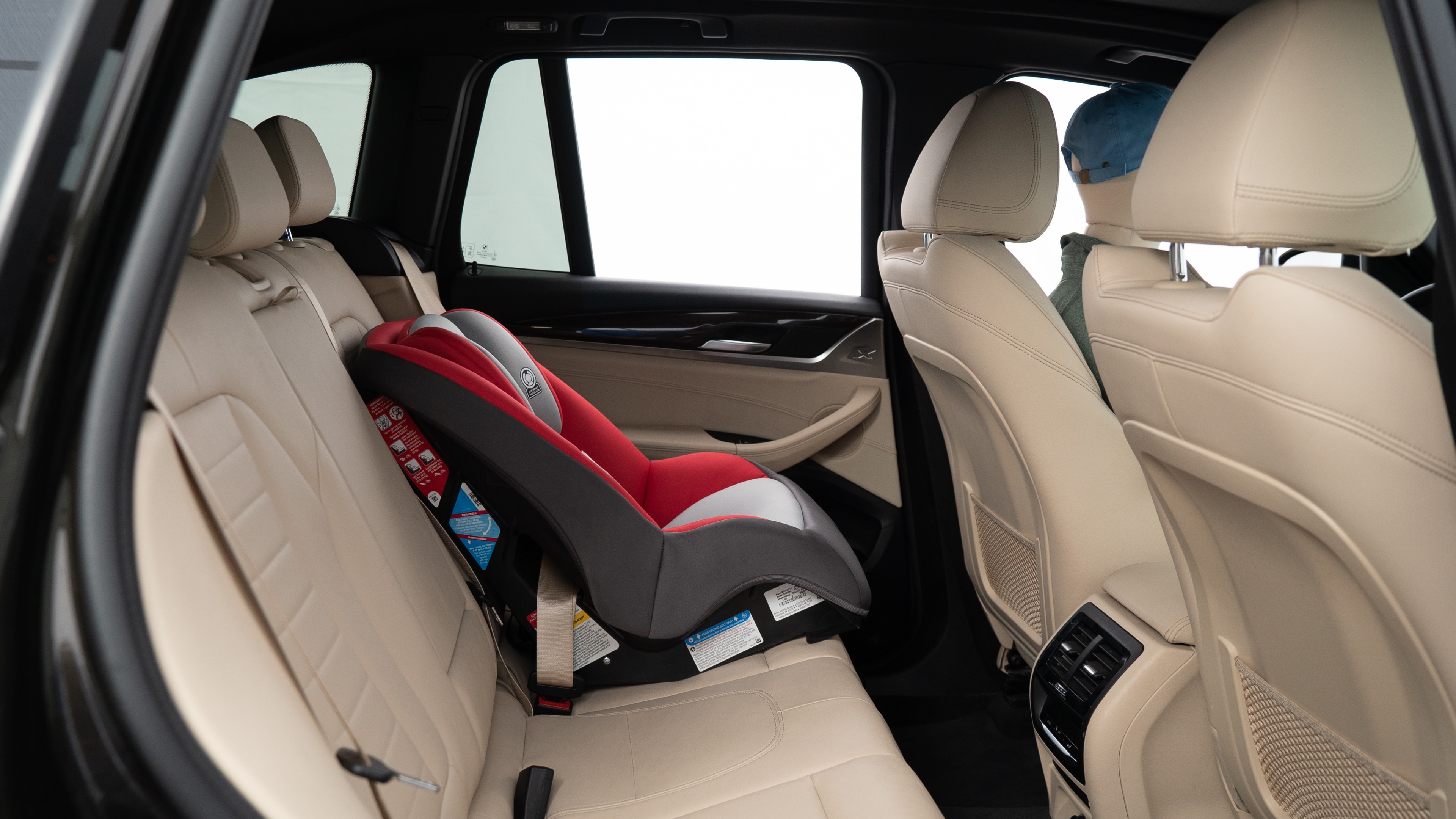 A series of second-row backseat photos is shown including one seating a baby seat, a dog and one seating a 6'1" mannequin.