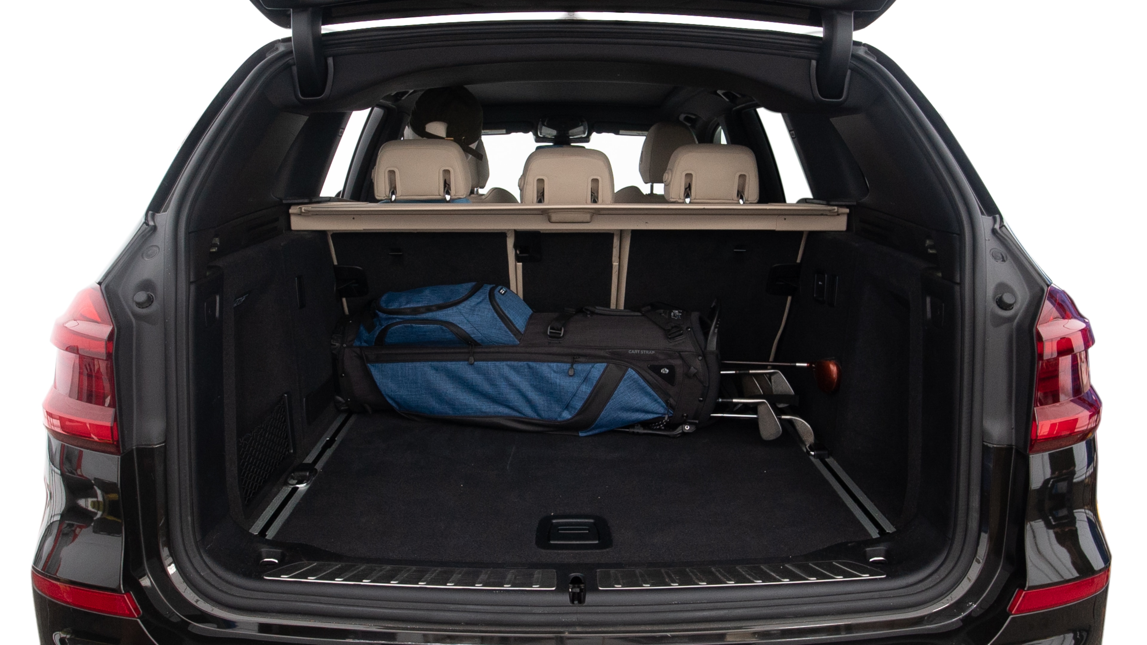 The trunk lid is open showing full view of the trunk. A baby stroller, three grocery carriers, two camping chairs in the carrying bag, and a set of golf clubs are placed inside.