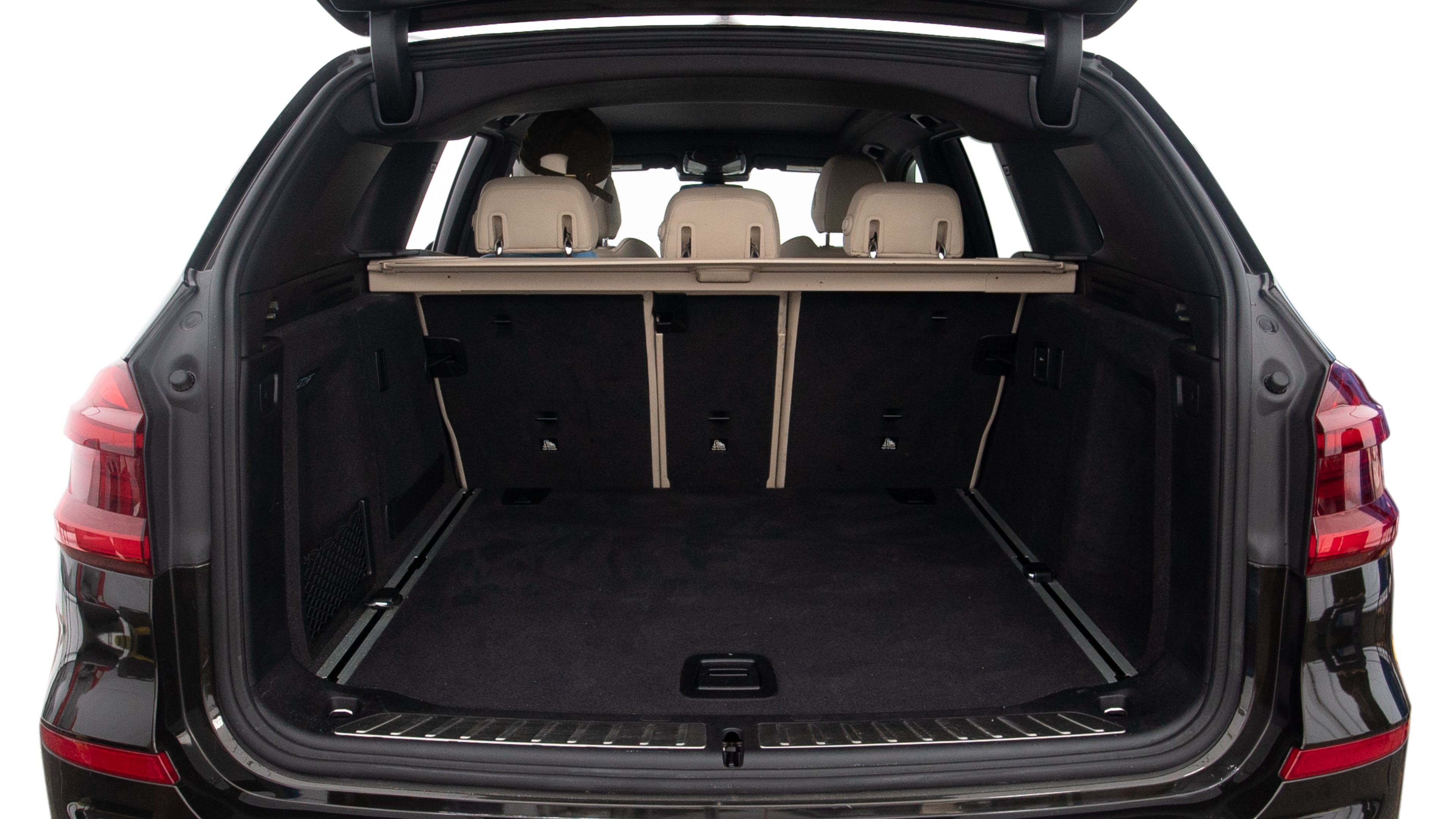 The trunk lid is open, showing full view of the trunk space. Two large and two small suitcases are placed inside.