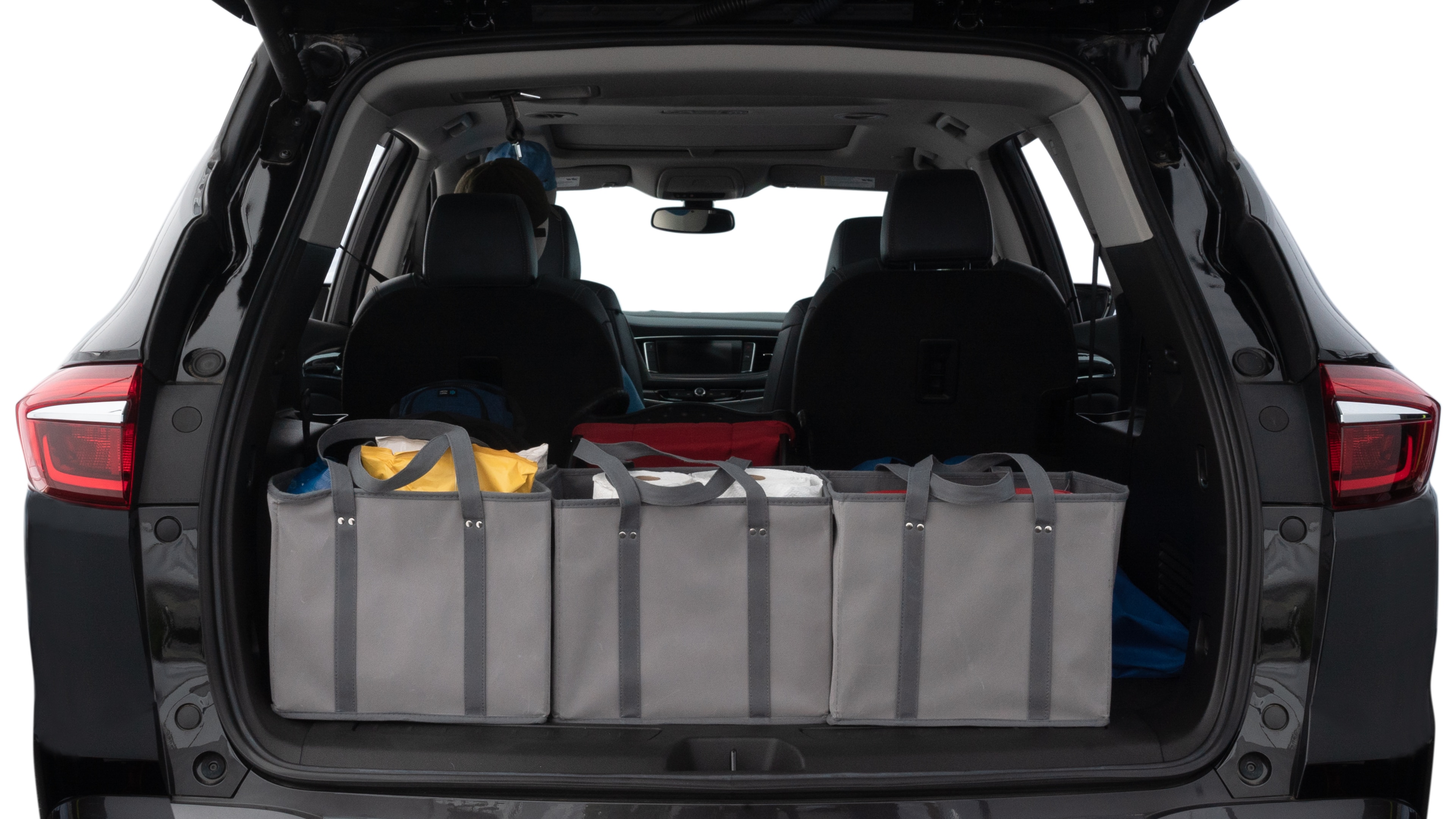 The trunk lid is open showing full view of the trunk. A baby stroller, three grocery carriers, two camping chairs in the carrying bag, and a set of golf clubs are placed inside.