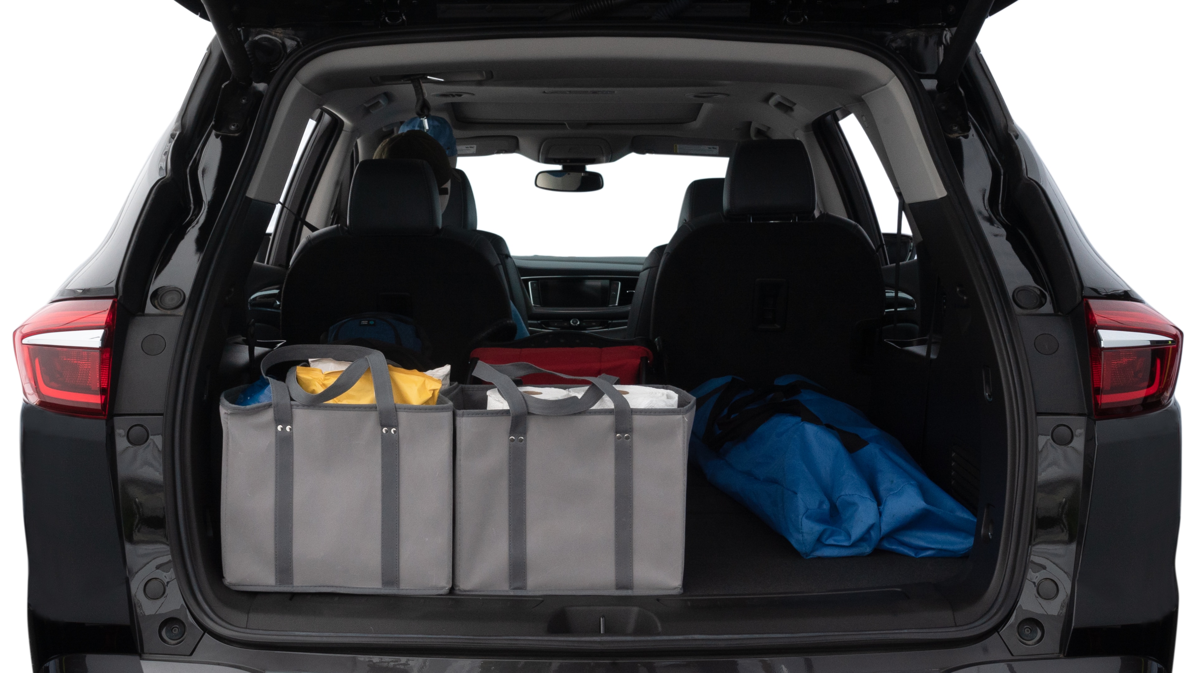 The trunk lid is open showing full view of the trunk. A baby stroller, three grocery carriers, two camping chairs in the carrying bag, and a set of golf clubs are placed inside.