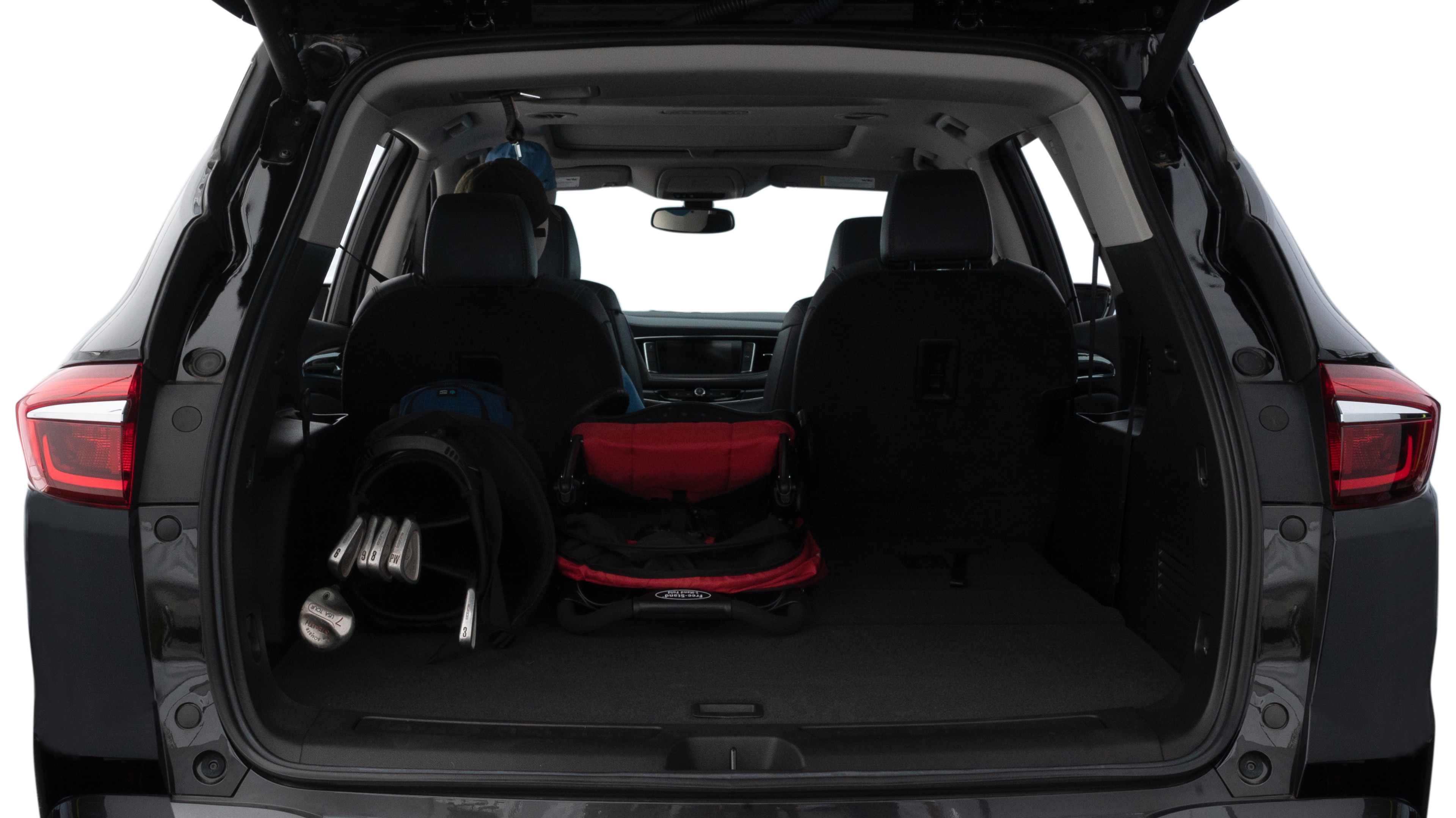 The trunk lid is open showing full view of the trunk. A baby stroller, three grocery carriers, two camping chairs in the carrying bag, and a set of golf clubs are placed inside.