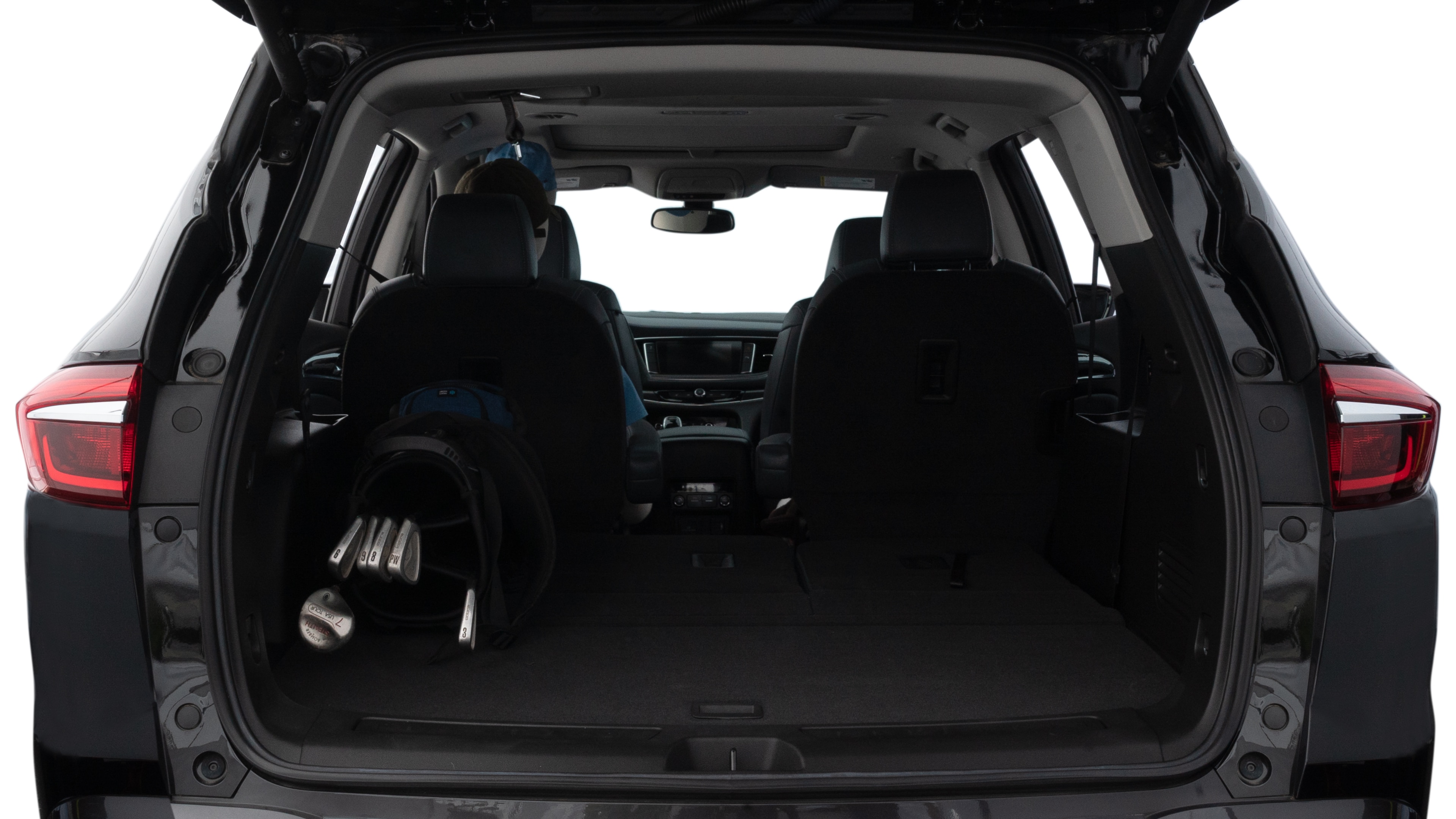 The trunk lid is open showing full view of the trunk. A baby stroller, three grocery carriers, two camping chairs in the carrying bag, and a set of golf clubs are placed inside.