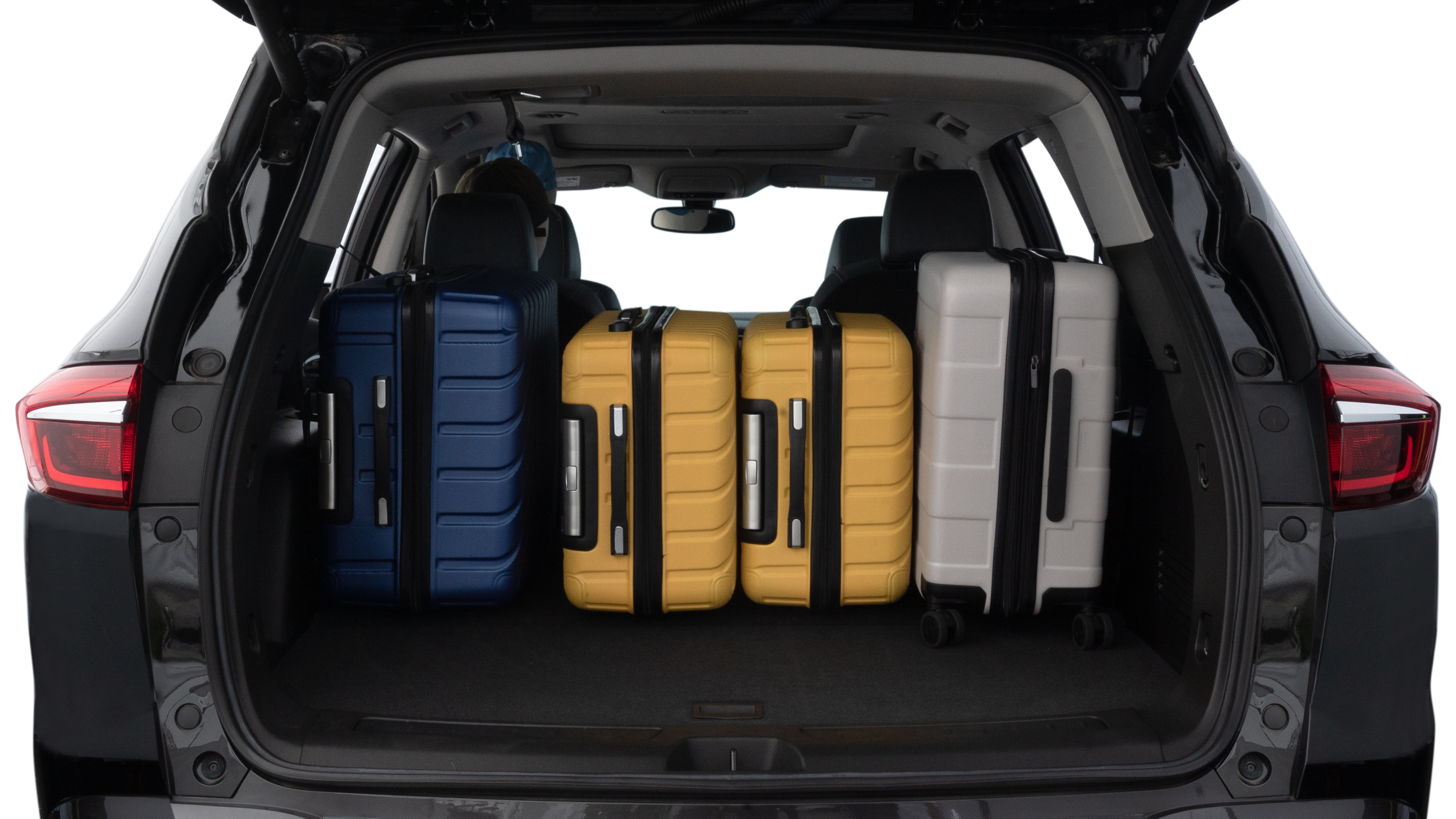 The trunk lid is open, showing full view of the trunk space. One large, two medium, and two small suitcases are placed inside.