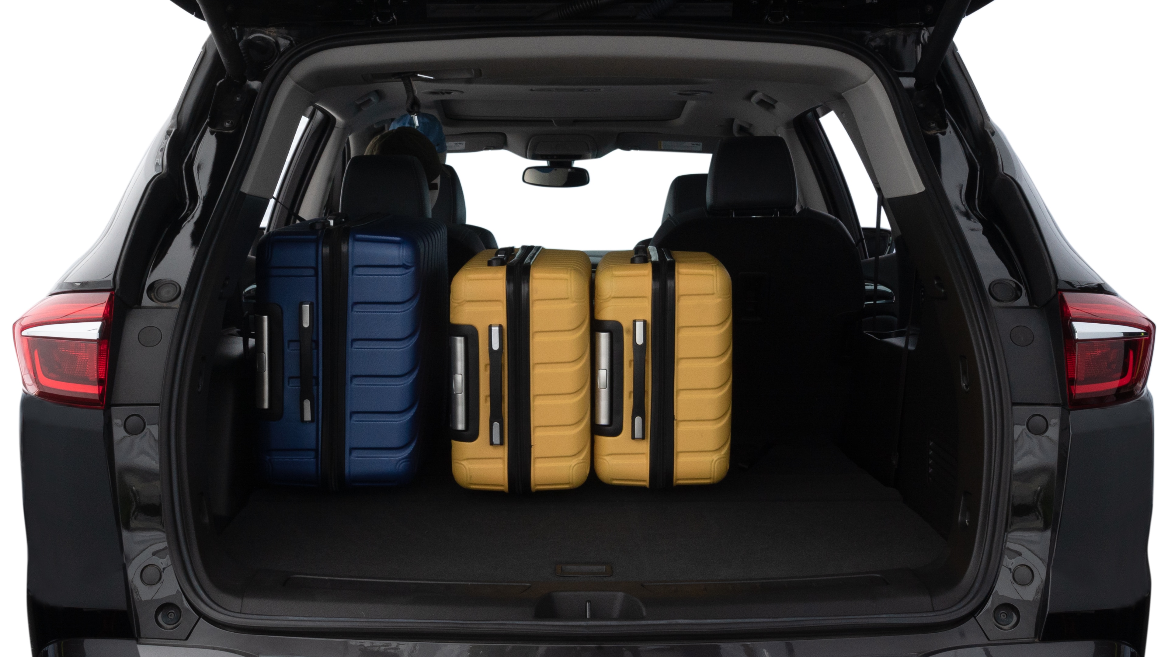 The trunk lid is open, showing full view of the trunk space. One large, two medium, and two small suitcases are placed inside.