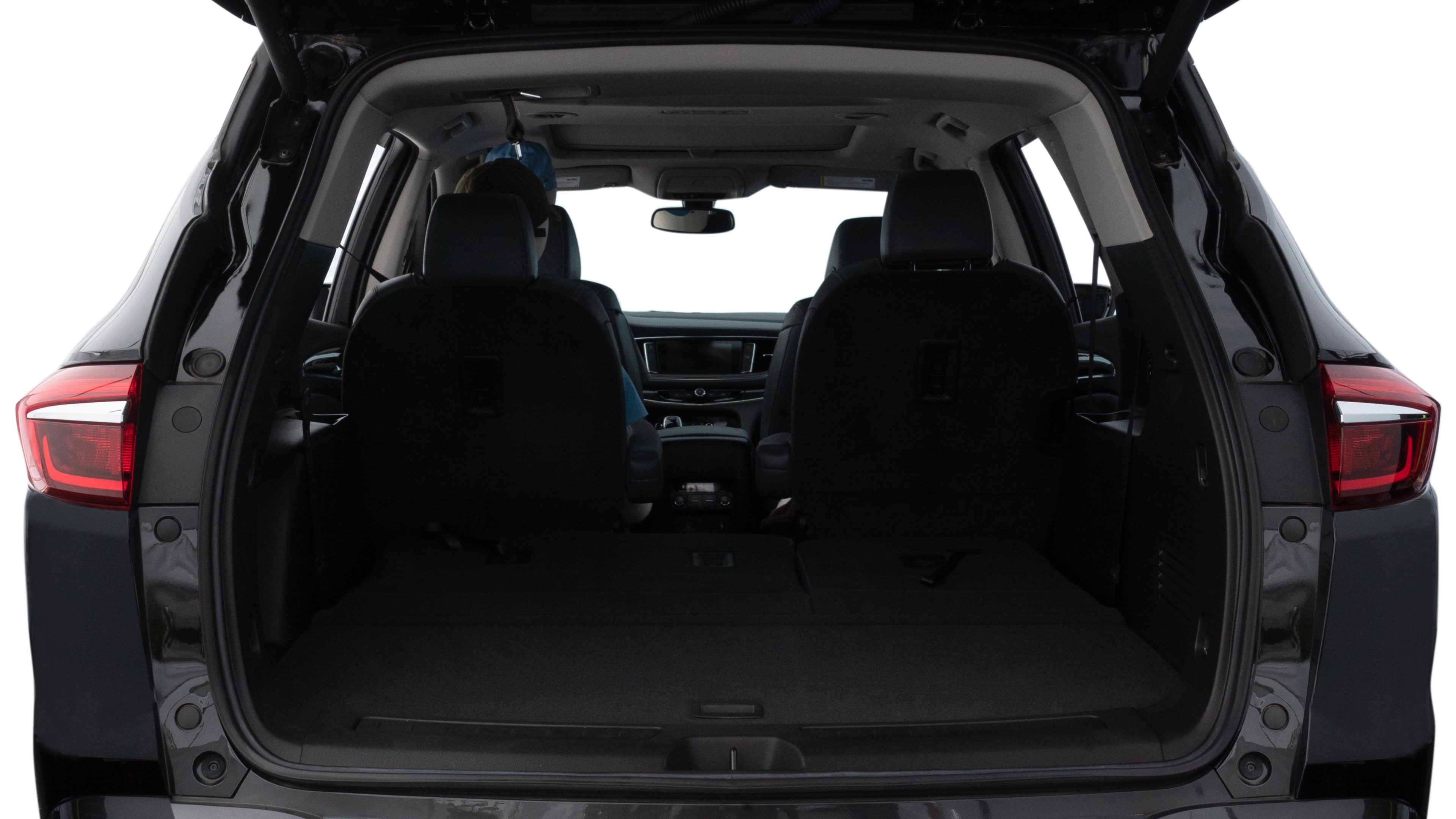 The trunk lid is open, showing full view of the trunk space. One large, two medium, and two small suitcases are placed inside.