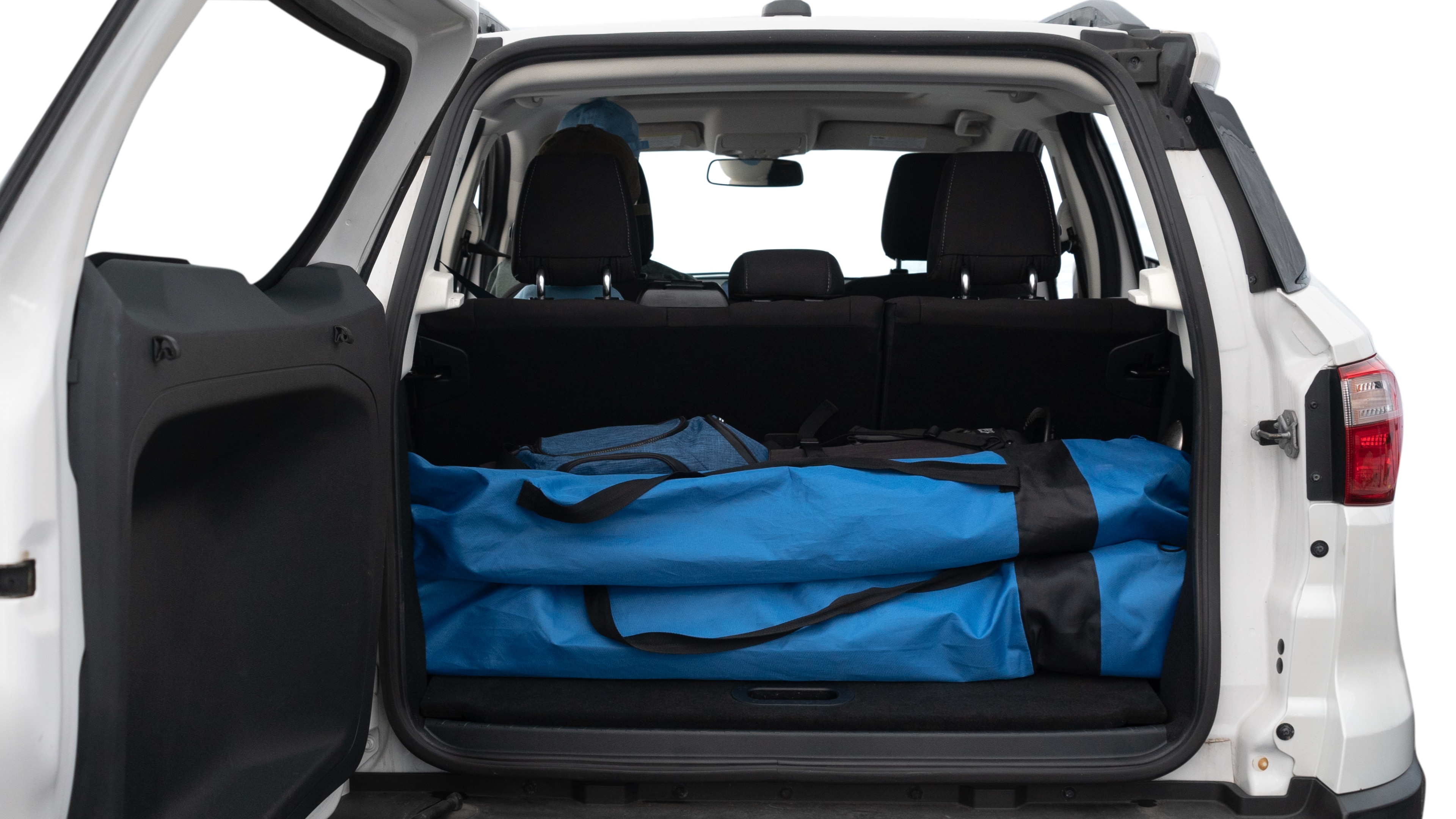 The trunk lid is open showing full view of the trunk. A baby stroller, three grocery carriers, two camping chairs in the carrying bag, and a set of golf clubs are placed inside.