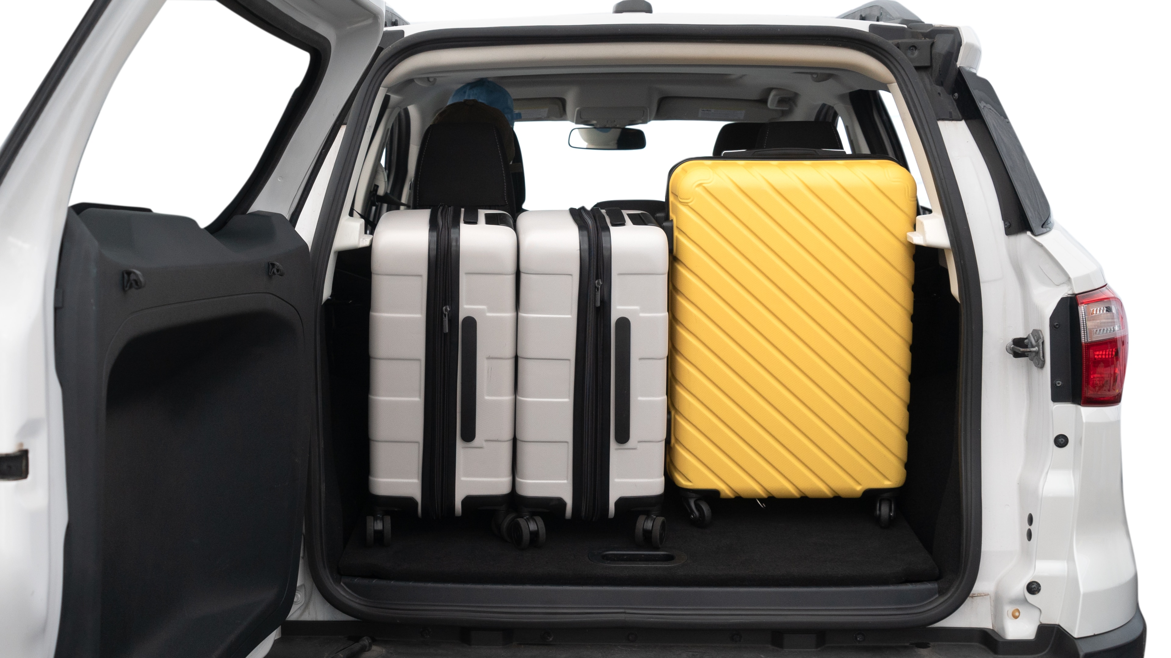 The trunk lid is open, showing full view of the trunk space. Two medium and two small suitcases are placed inside.