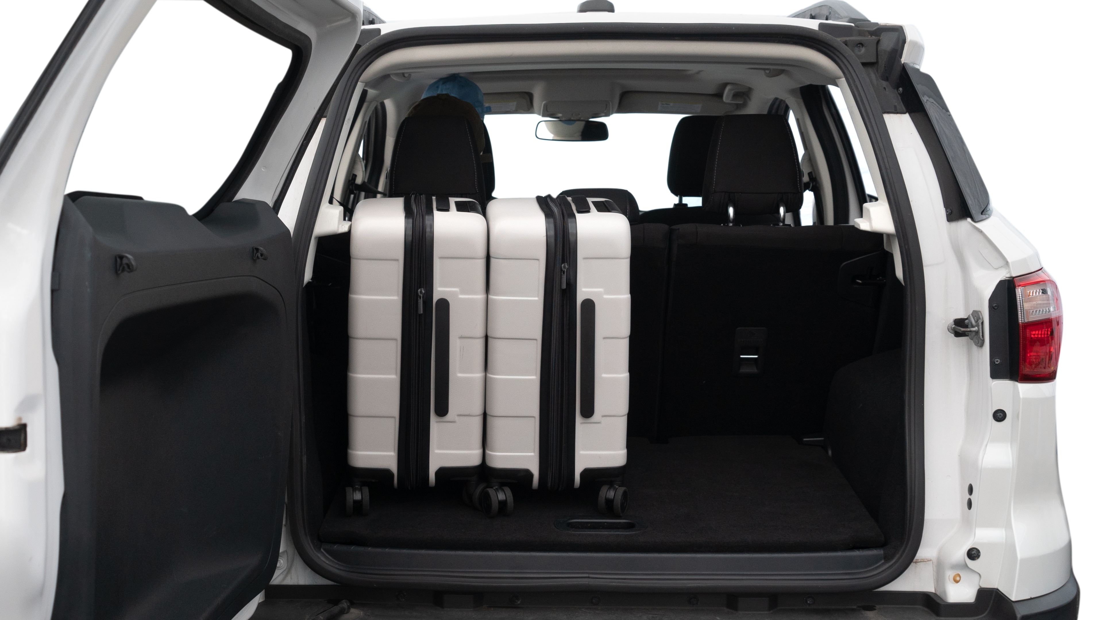 The trunk lid is open, showing full view of the trunk space. Two medium and two small suitcases are placed inside.