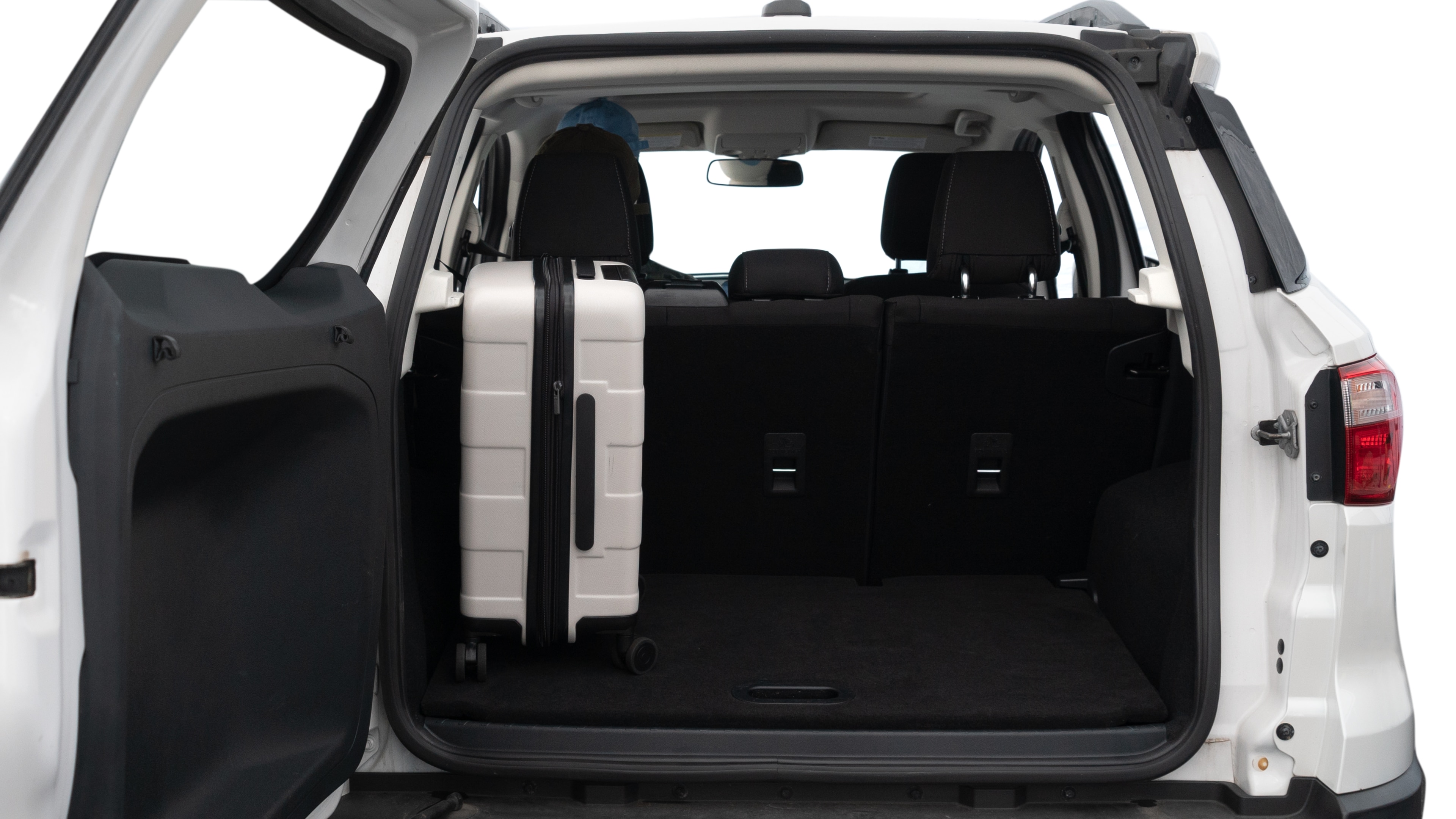 The trunk lid is open, showing full view of the trunk space. Two medium and two small suitcases are placed inside.