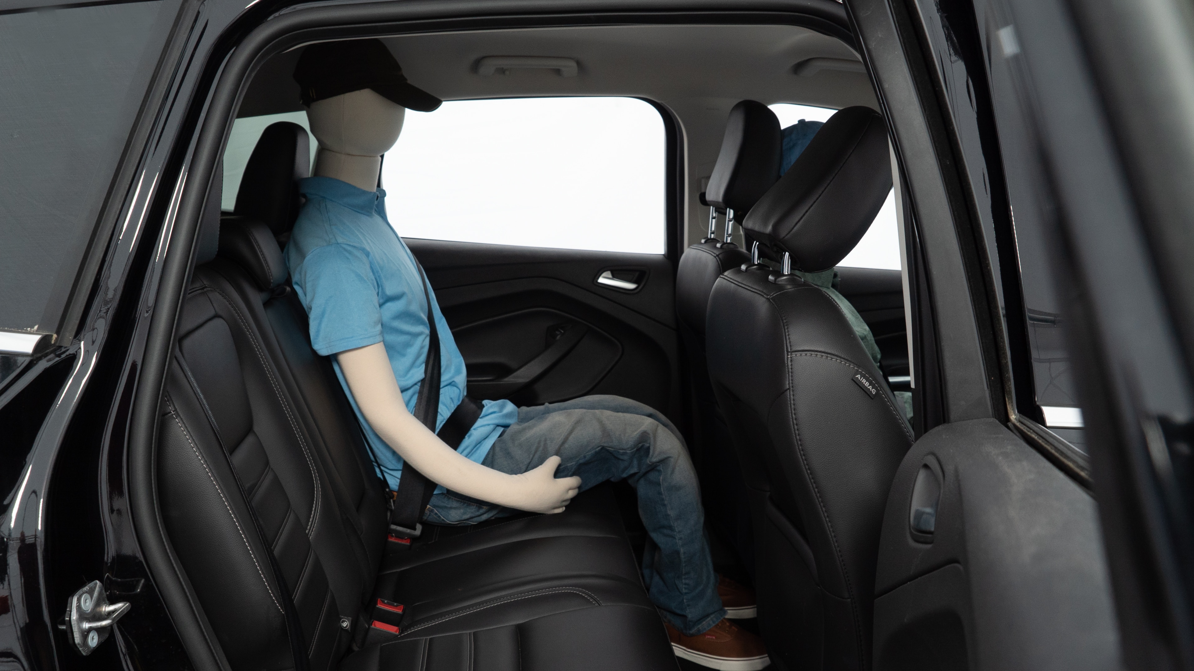 A series of second-row backseat photos is shown including one seating a baby seat and one seating a 6'1" mannequin.