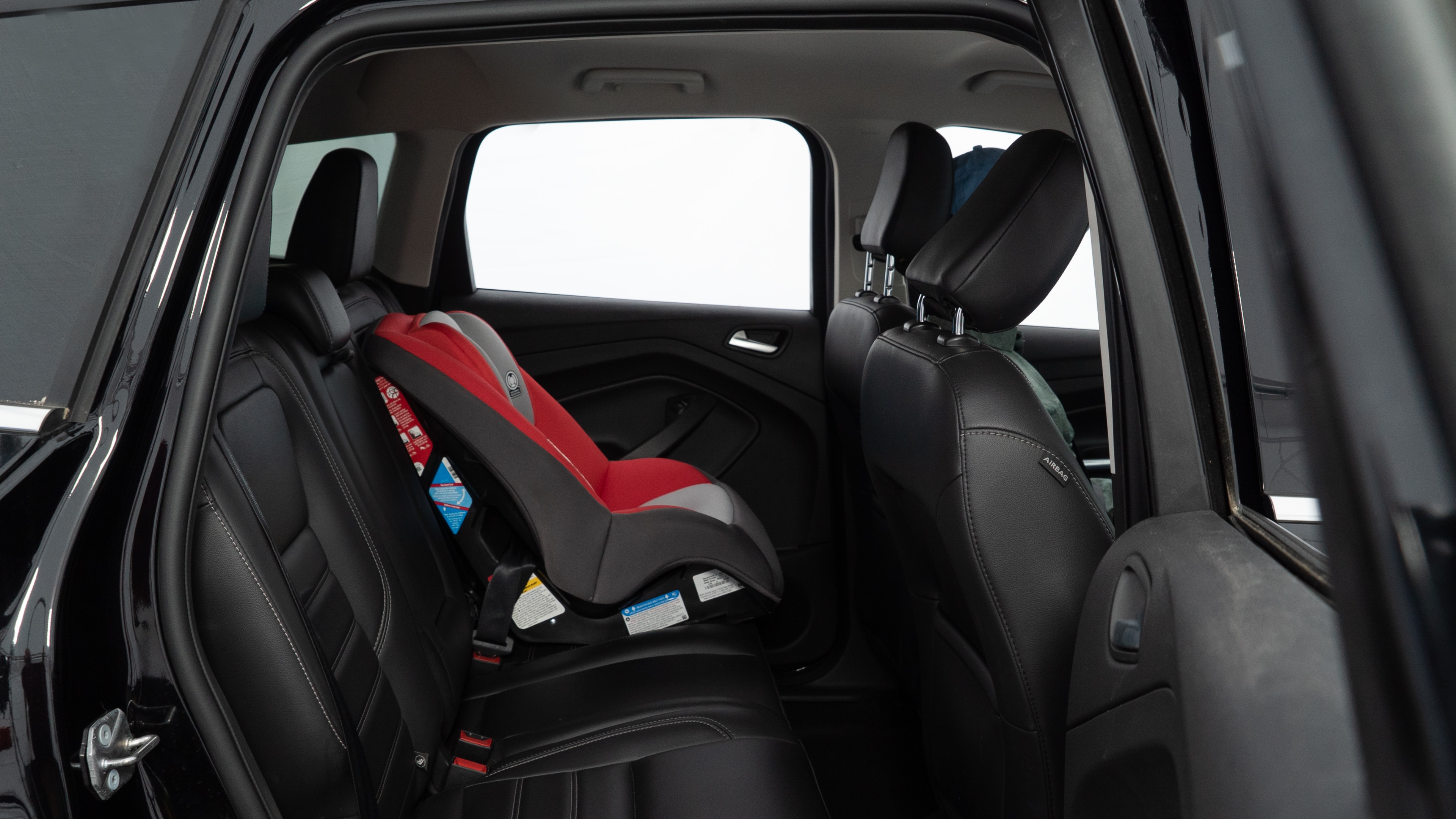 A series of second-row backseat photos is shown including one seating a baby seat and one seating a 6'1" mannequin.