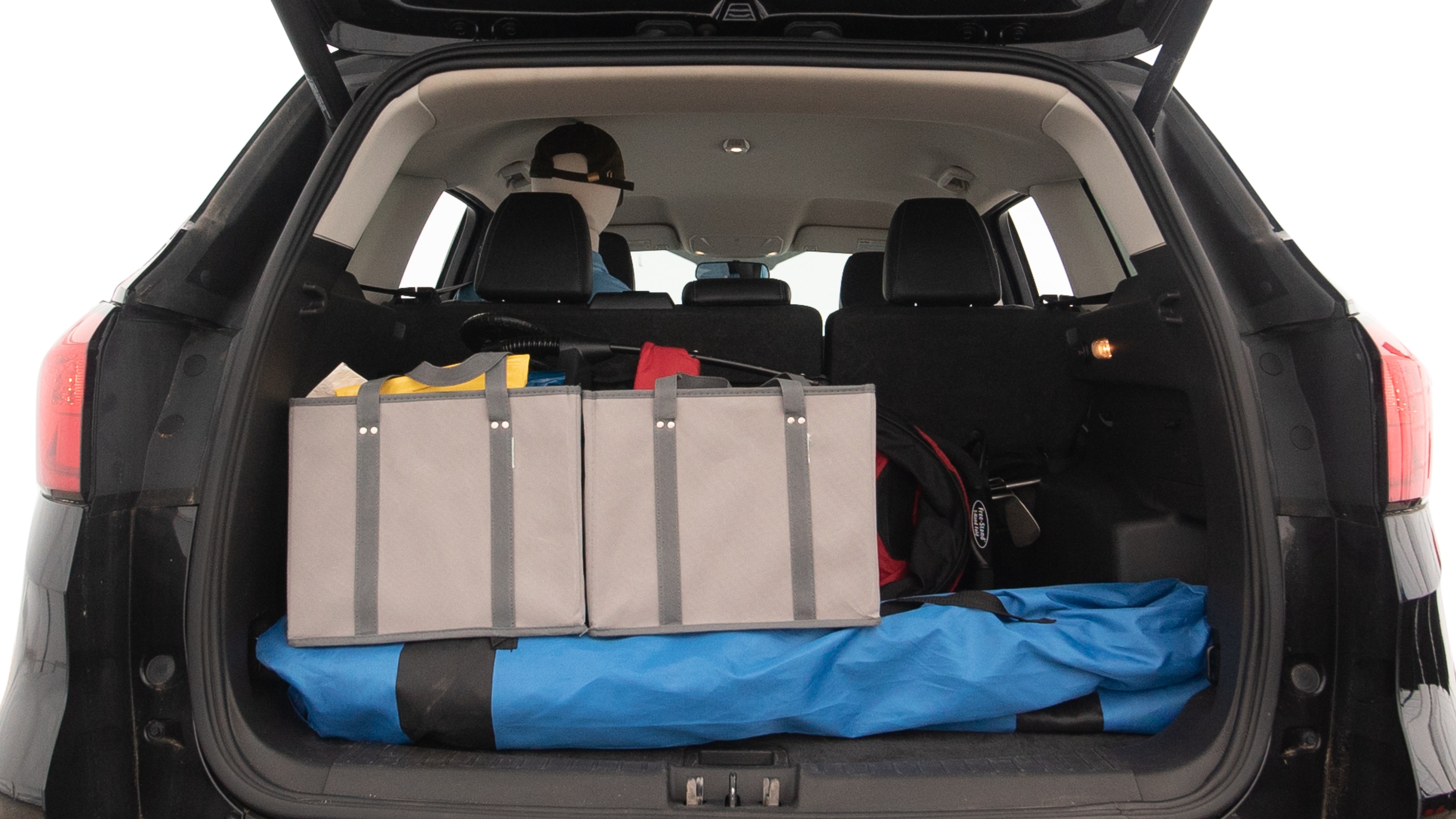 The trunk lid is open showing full view of the trunk. A baby stroller, three grocery carriers, two camping chairs in the carrying bag, and a set of golf clubs are placed inside.