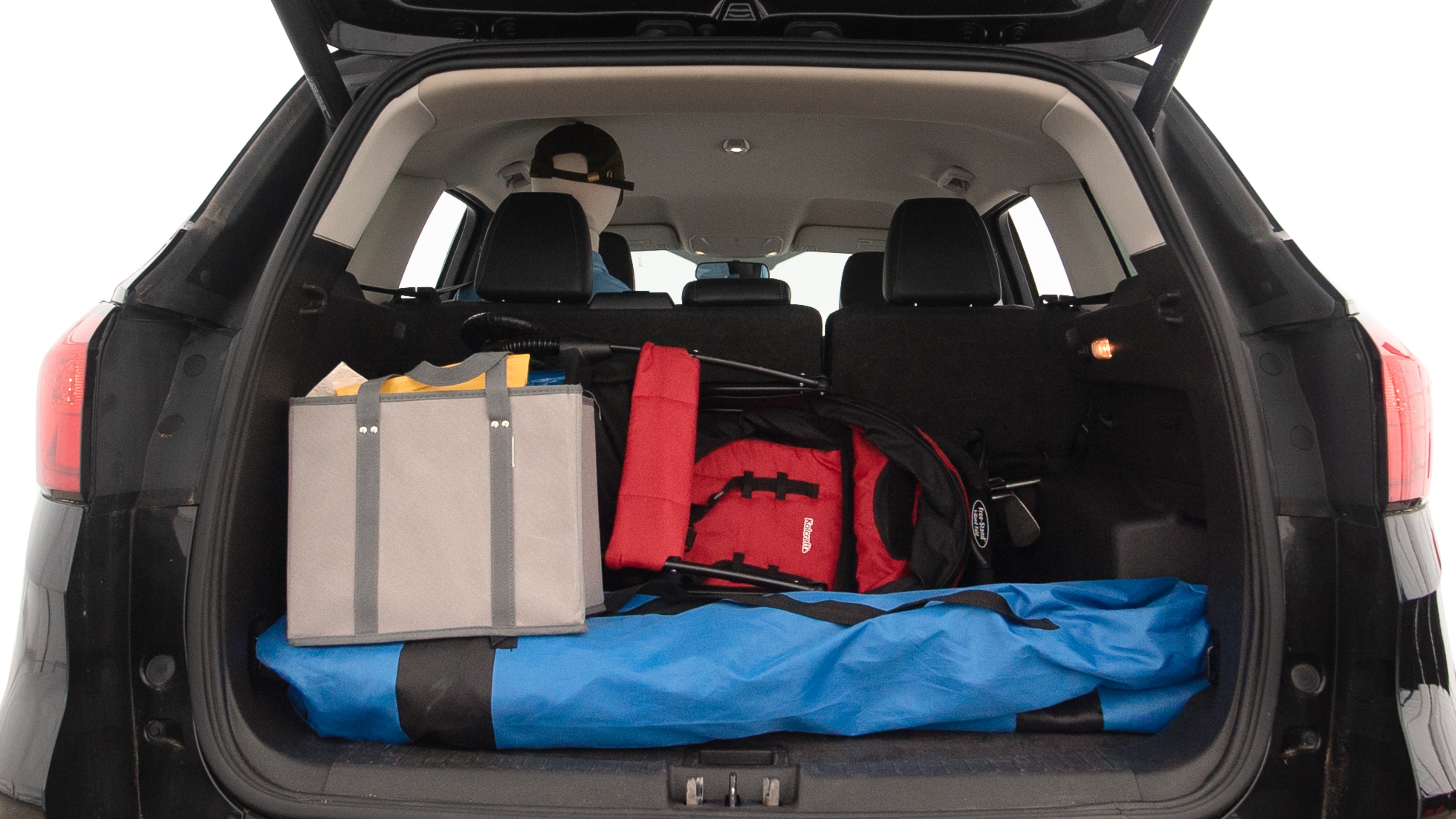 The trunk lid is open showing full view of the trunk. A baby stroller, three grocery carriers, two camping chairs in the carrying bag, and a set of golf clubs are placed inside.