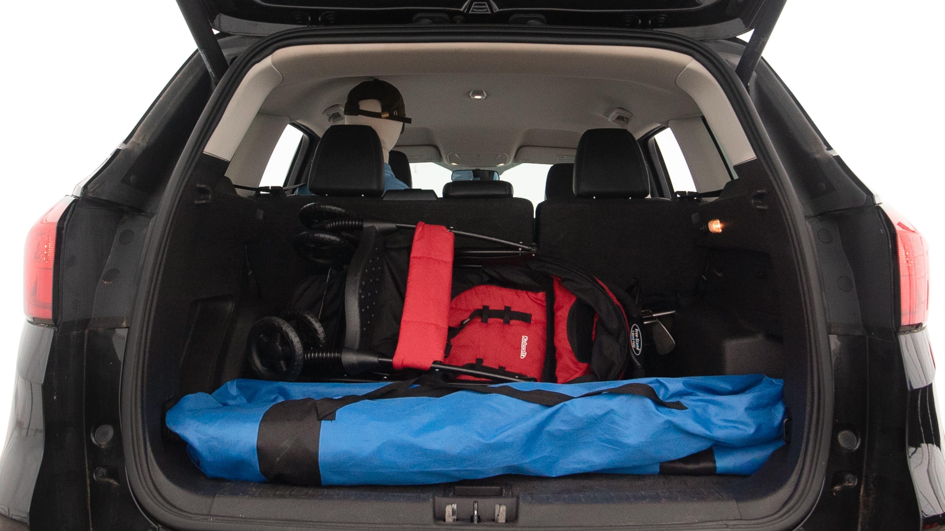 The trunk lid is open showing full view of the trunk. A baby stroller, three grocery carriers, two camping chairs in the carrying bag, and a set of golf clubs are placed inside.