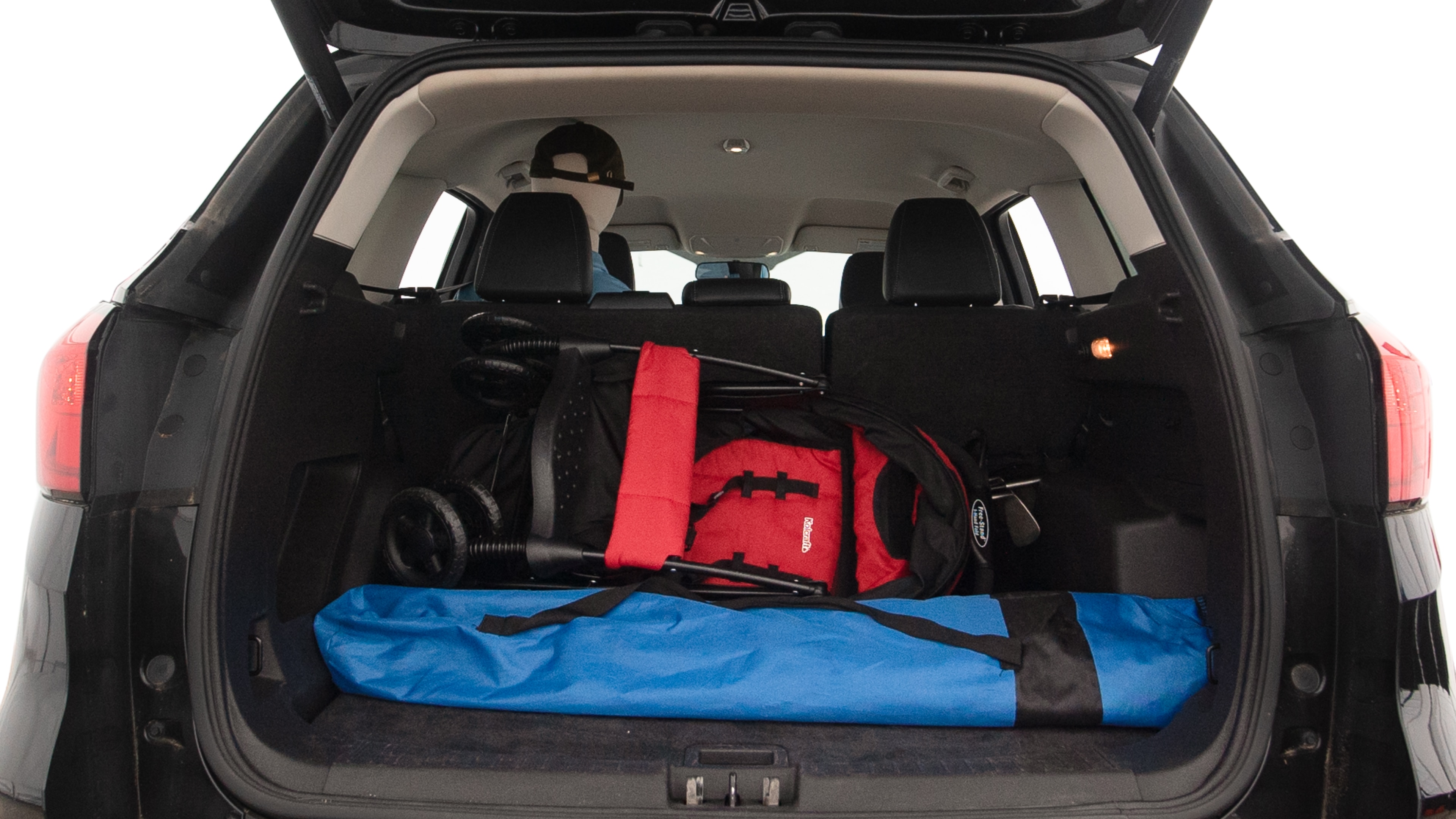The trunk lid is open showing full view of the trunk. A baby stroller, three grocery carriers, two camping chairs in the carrying bag, and a set of golf clubs are placed inside.
