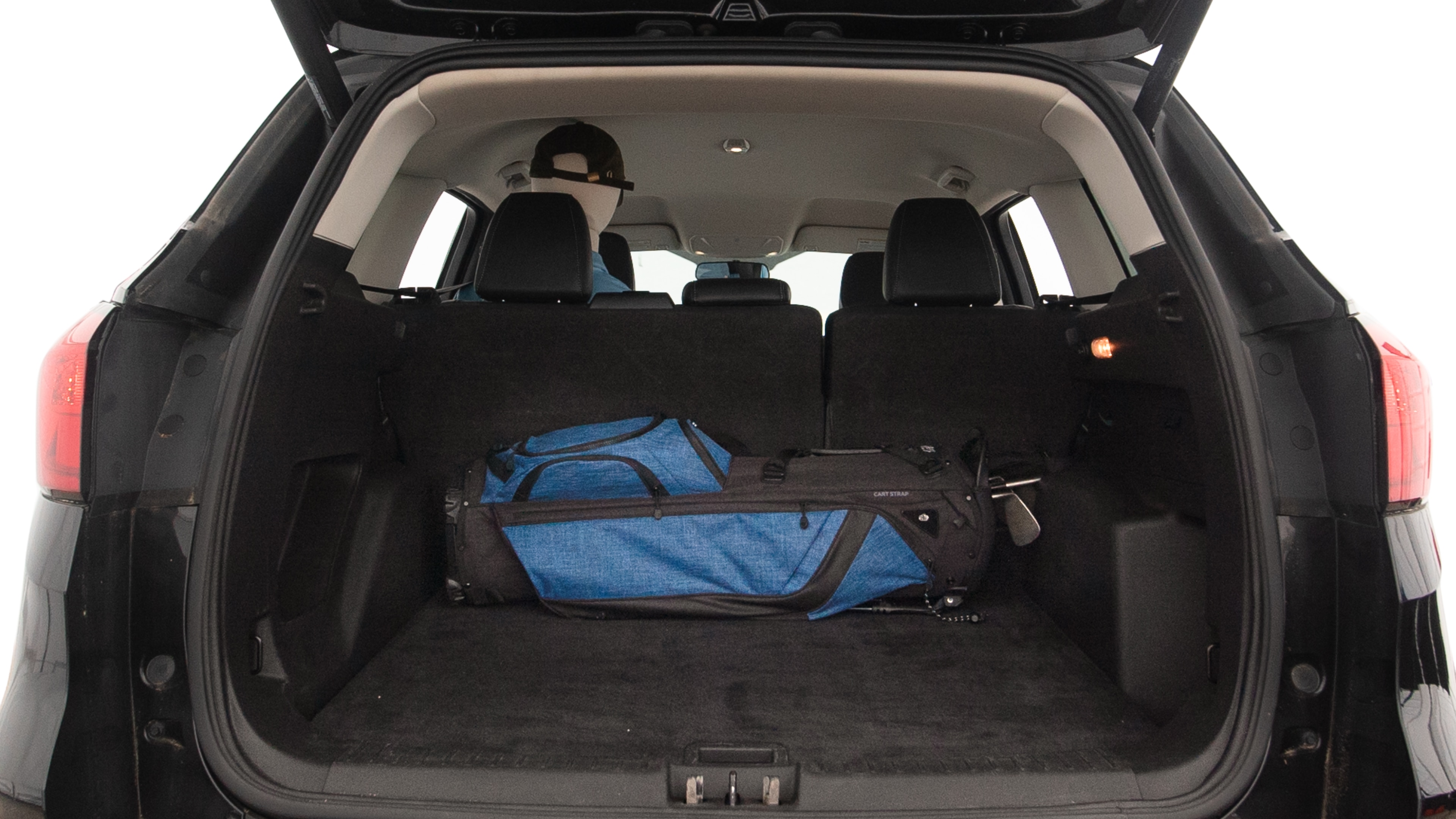 The trunk lid is open showing full view of the trunk. A baby stroller, three grocery carriers, two camping chairs in the carrying bag, and a set of golf clubs are placed inside.
