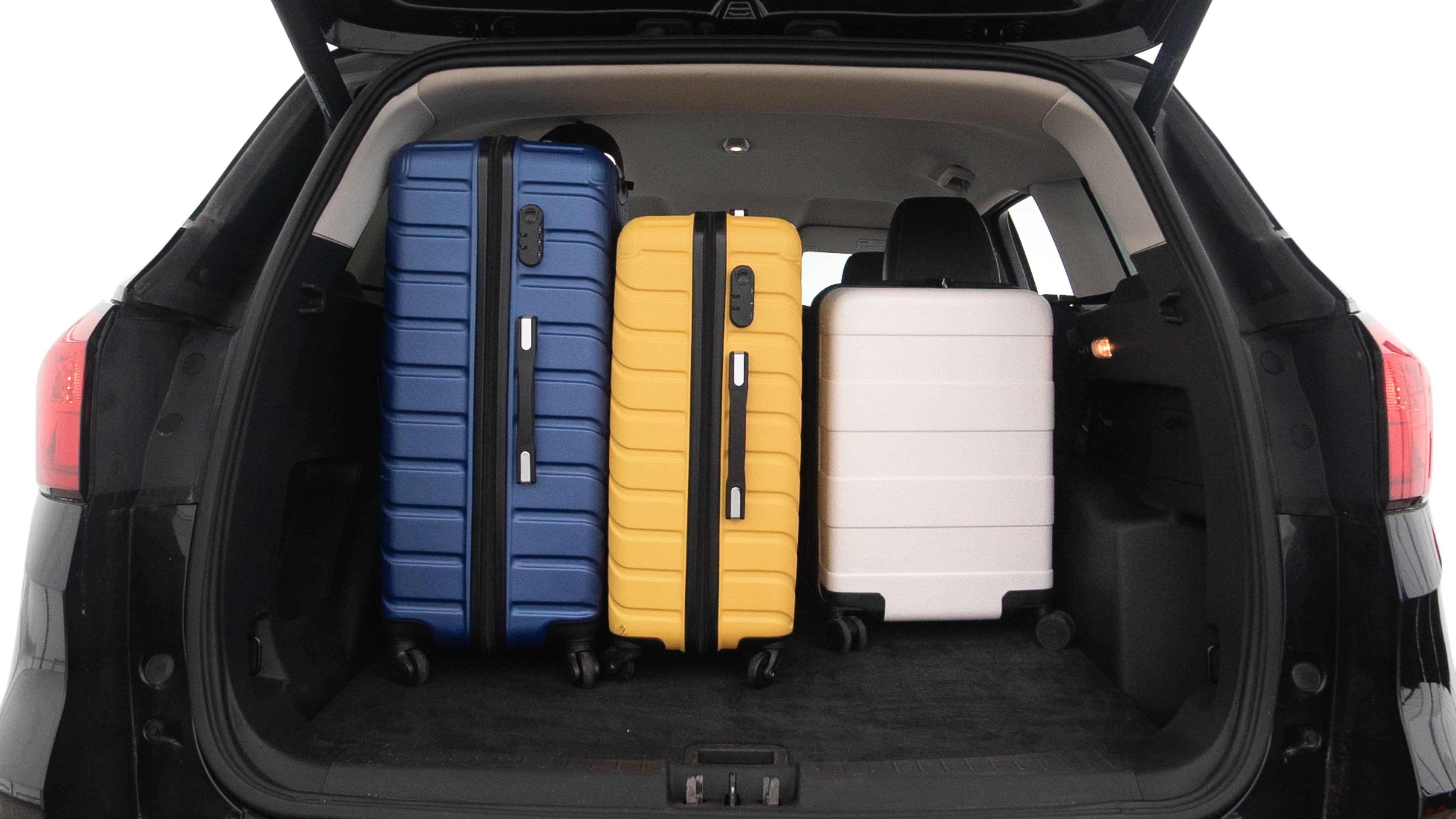 The trunk lid is open, showing full view of the trunk space. One large, two medium and two small suitcases are placed inside.