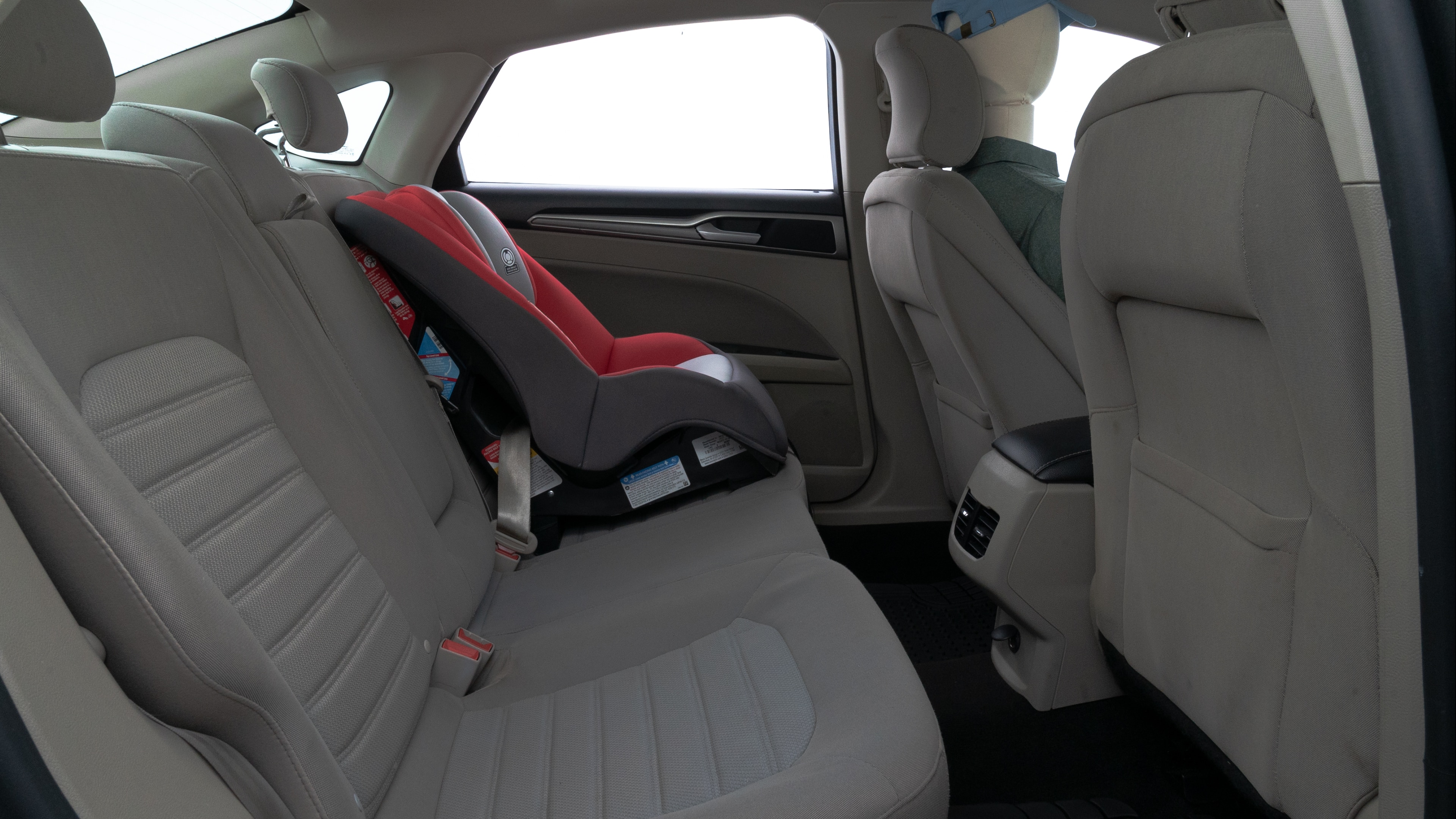 A series of second-row backseat photos is shown including one seating a baby seat and one seating a 6'1" mannequin.