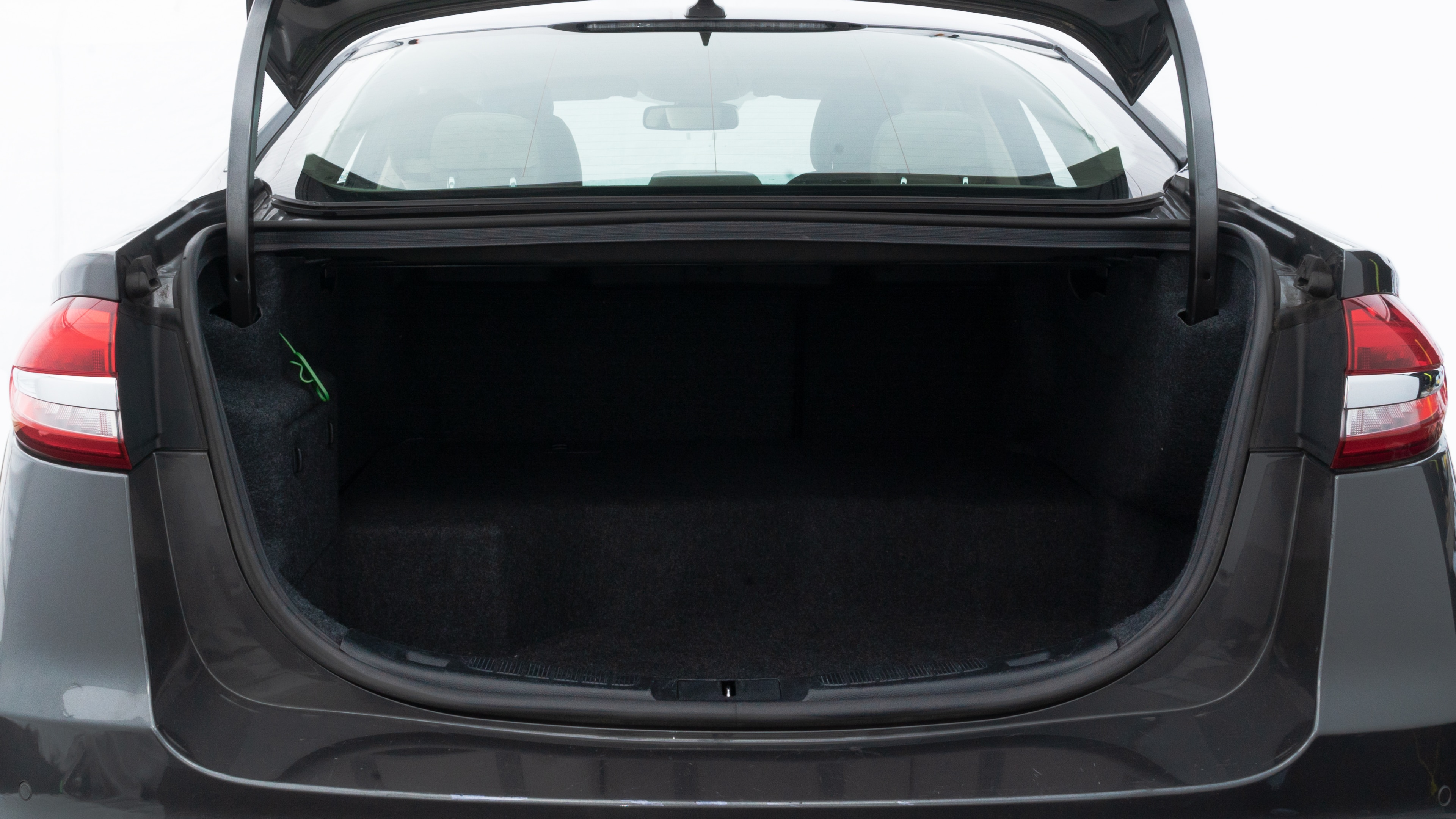 The trunk lid is open showing full view of the trunk. A baby stroller, three grocery carriers, two camping chairs in the carrying bag, and a set of golf clubs are placed inside.