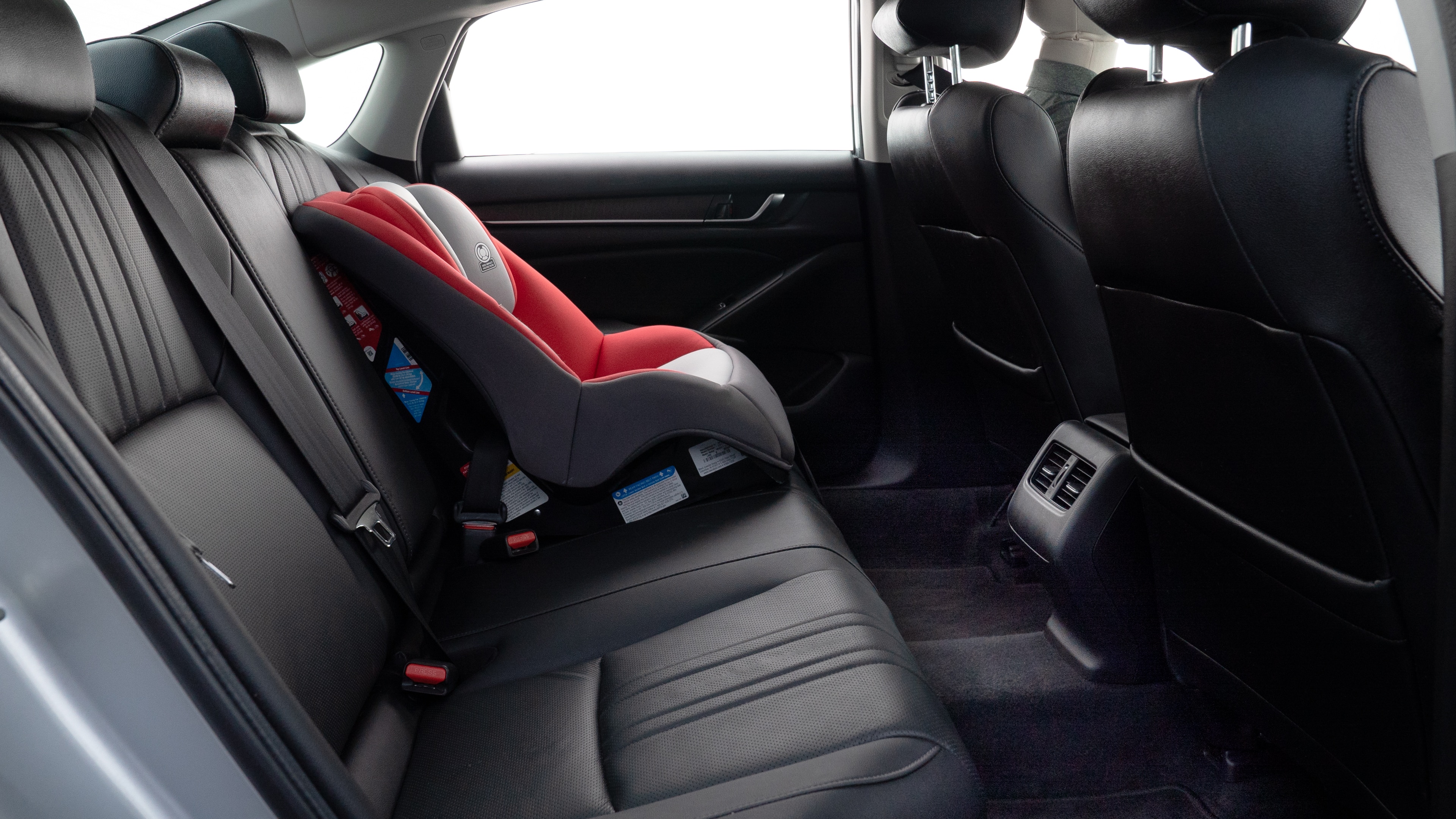 A series of second-row backseat photos is shown including one seating a baby seat and one seating a 6'1" mannequin.